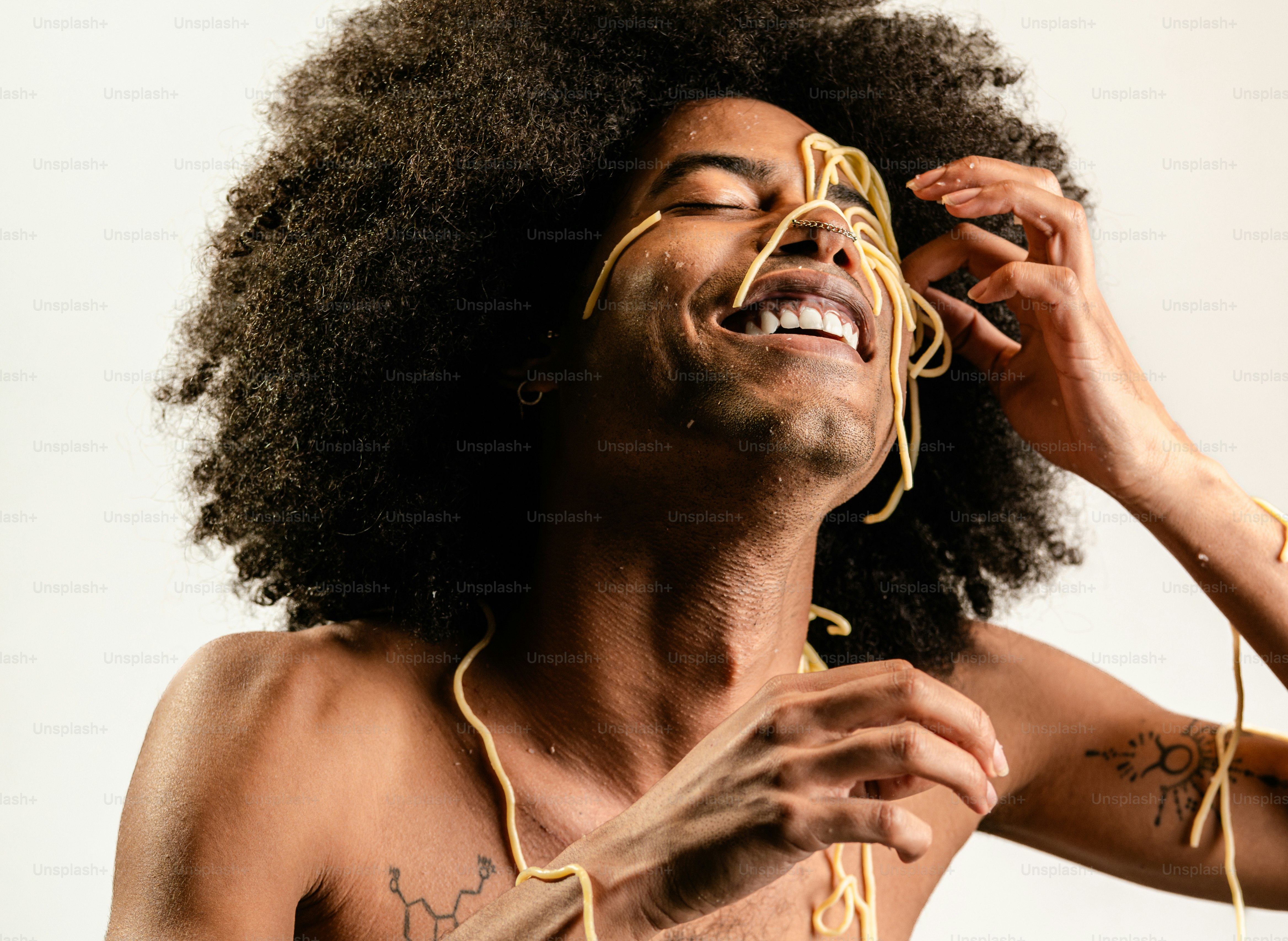 Ein Mann mit einem Afro hält eine Schnur um seinen Hals