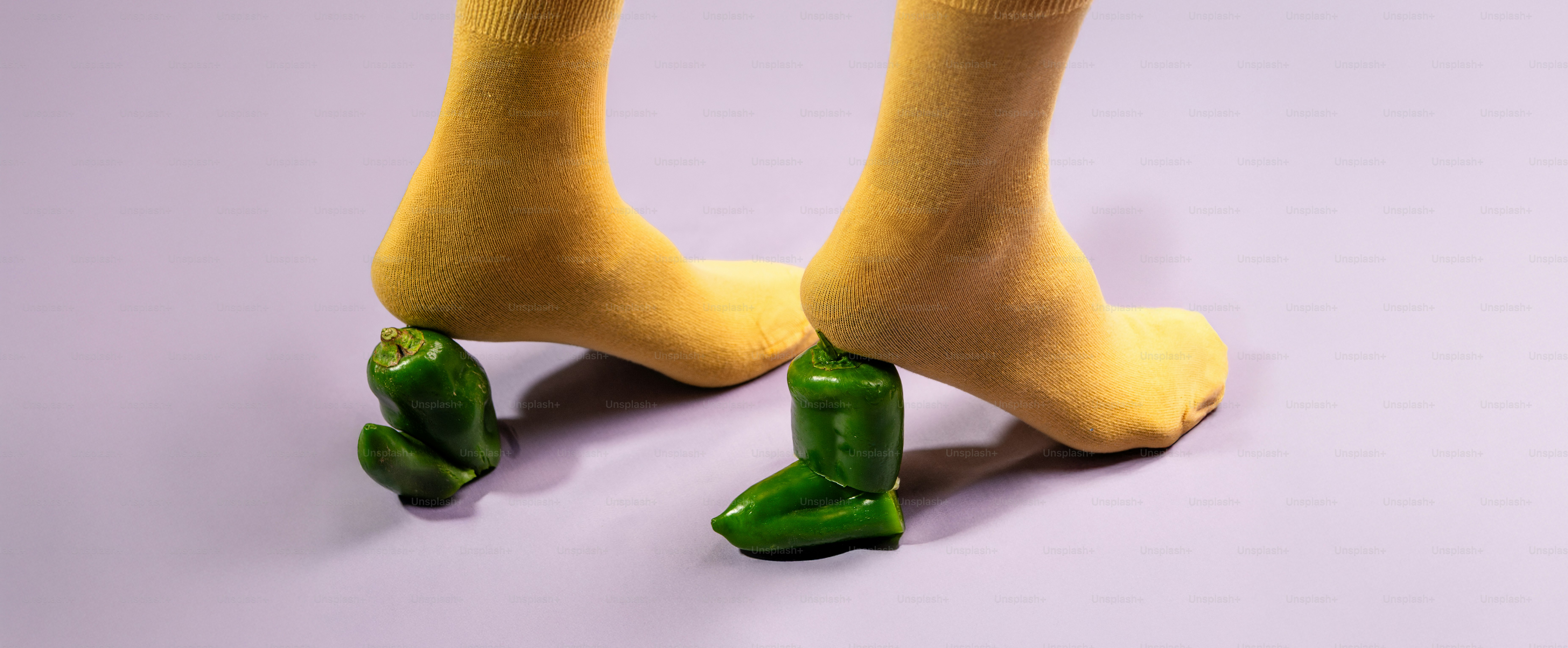 A pair of feet with yellow socks and green peppers