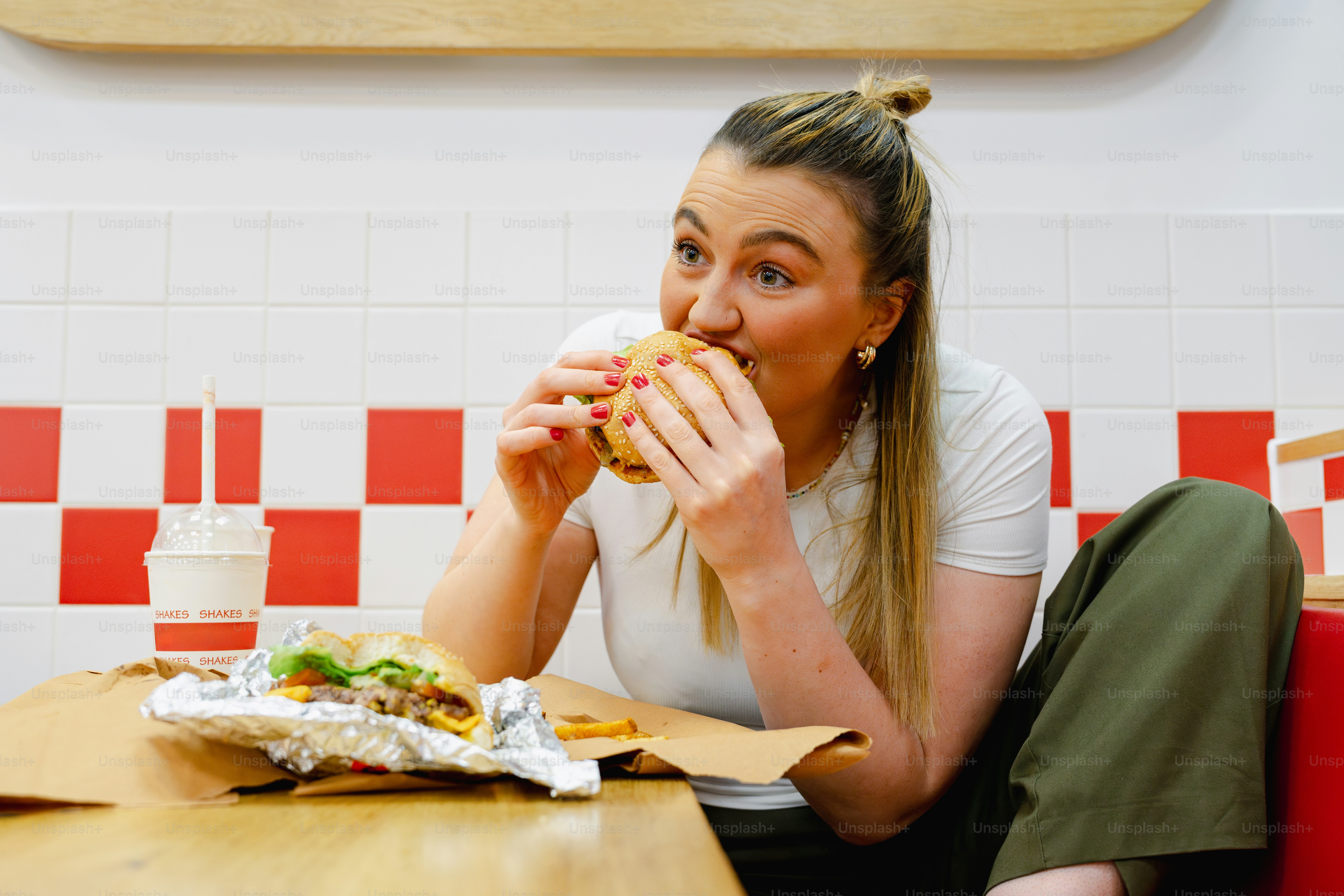 Eine Frau, die an einem Tisch sitzt und ein Sandwich isst