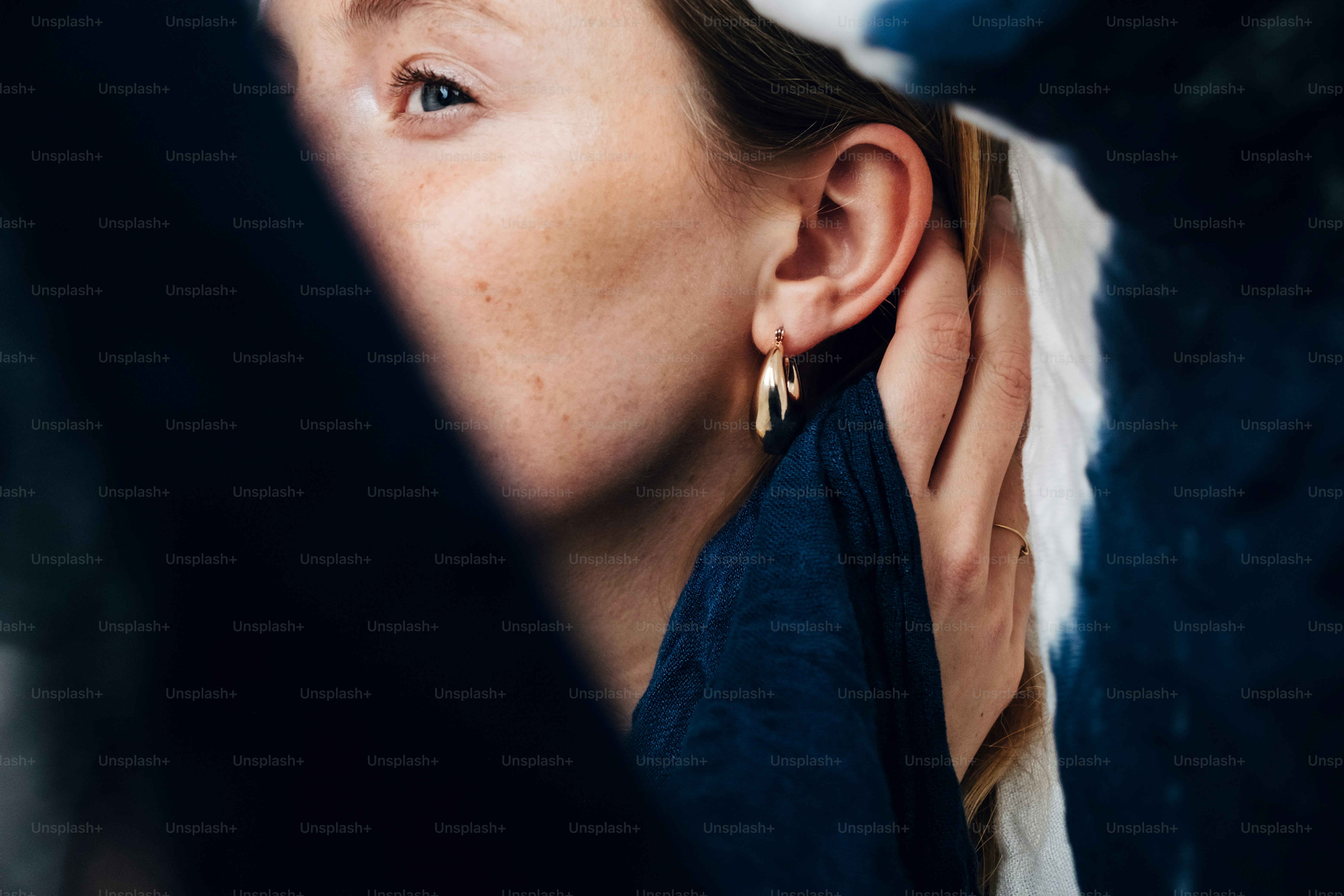 A woman wearing a pair of large gold hoop earrings