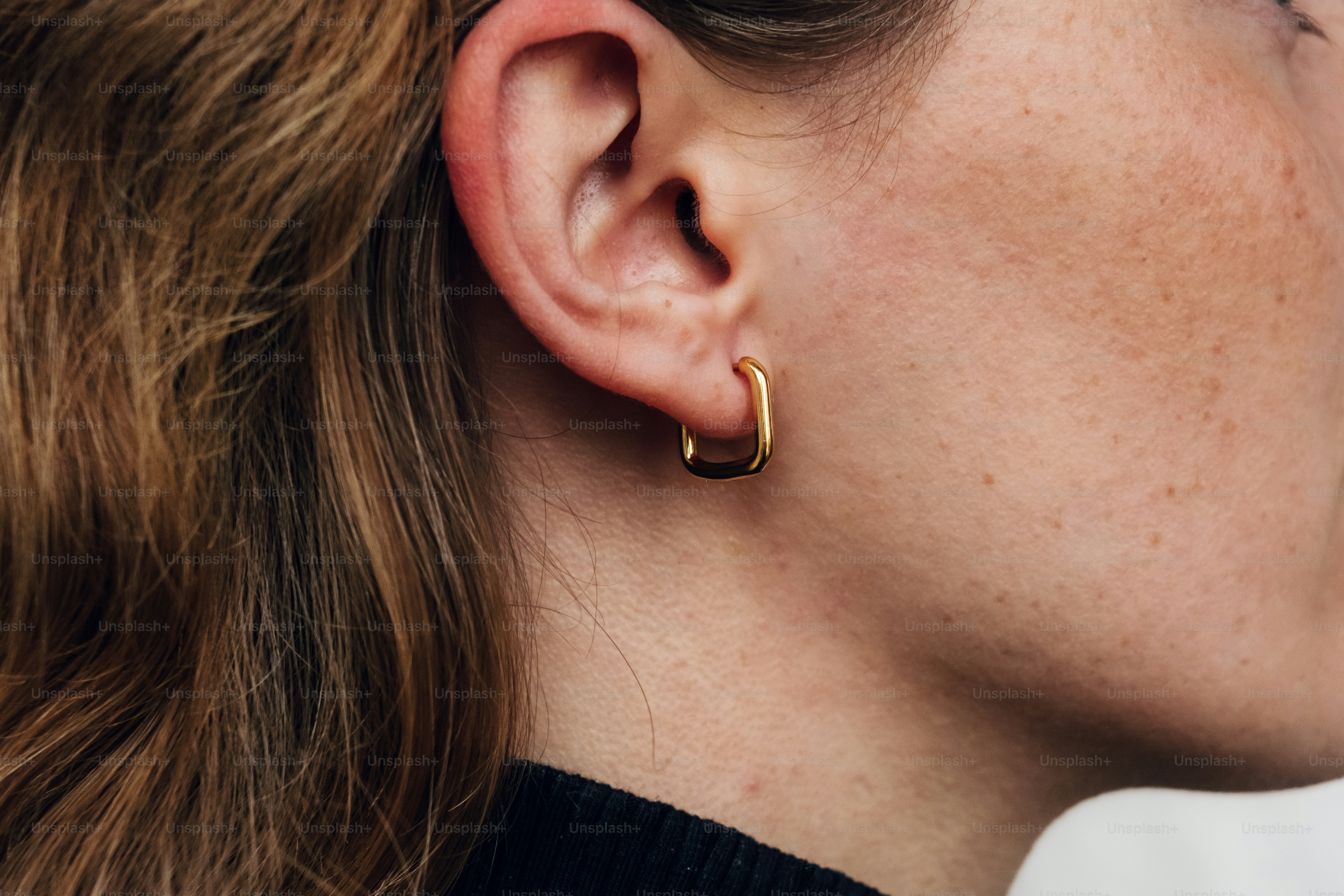 A close up of a person wearing a pair of earrings