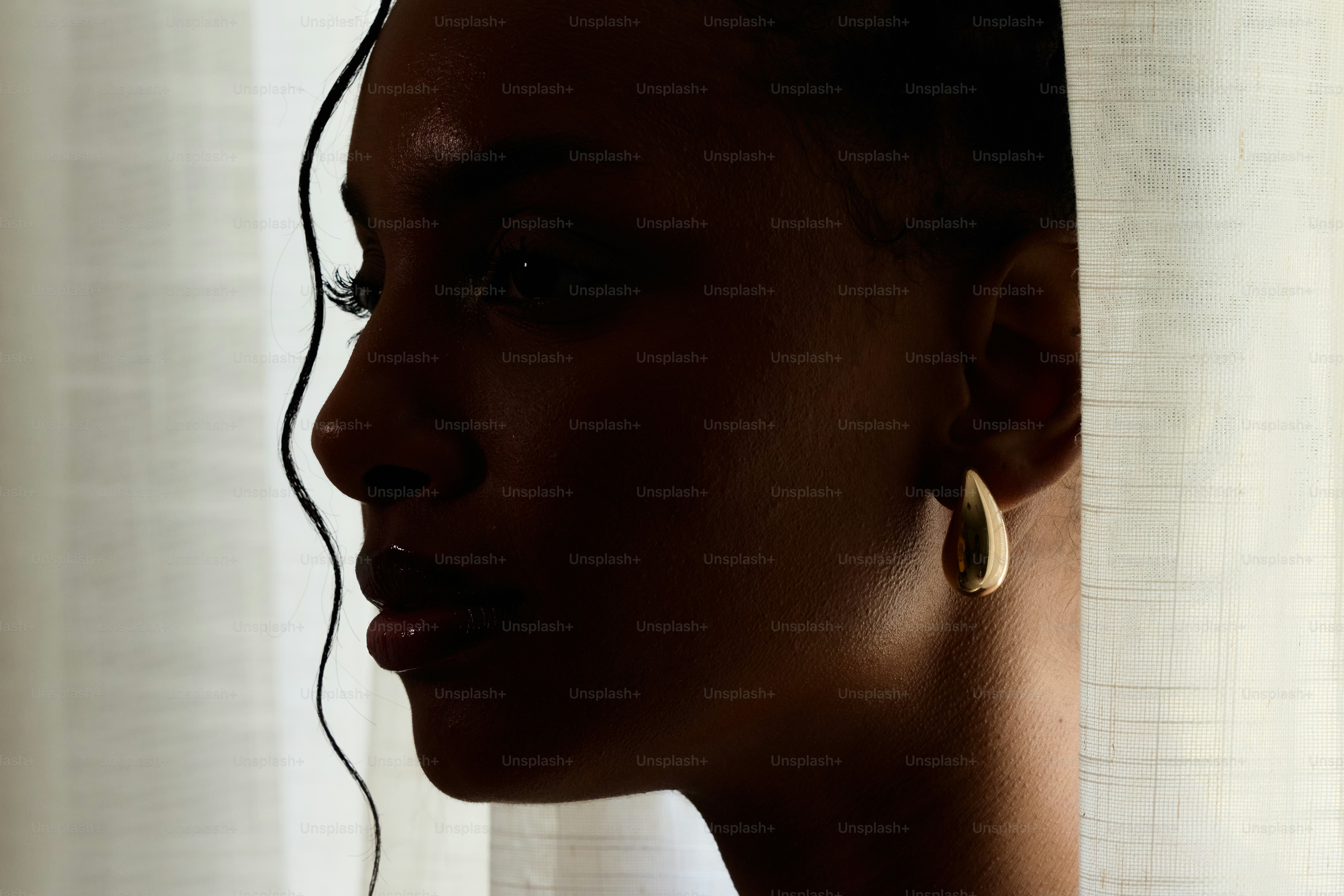 Seorang wanita bergaun hitam melihat ke luar jendela