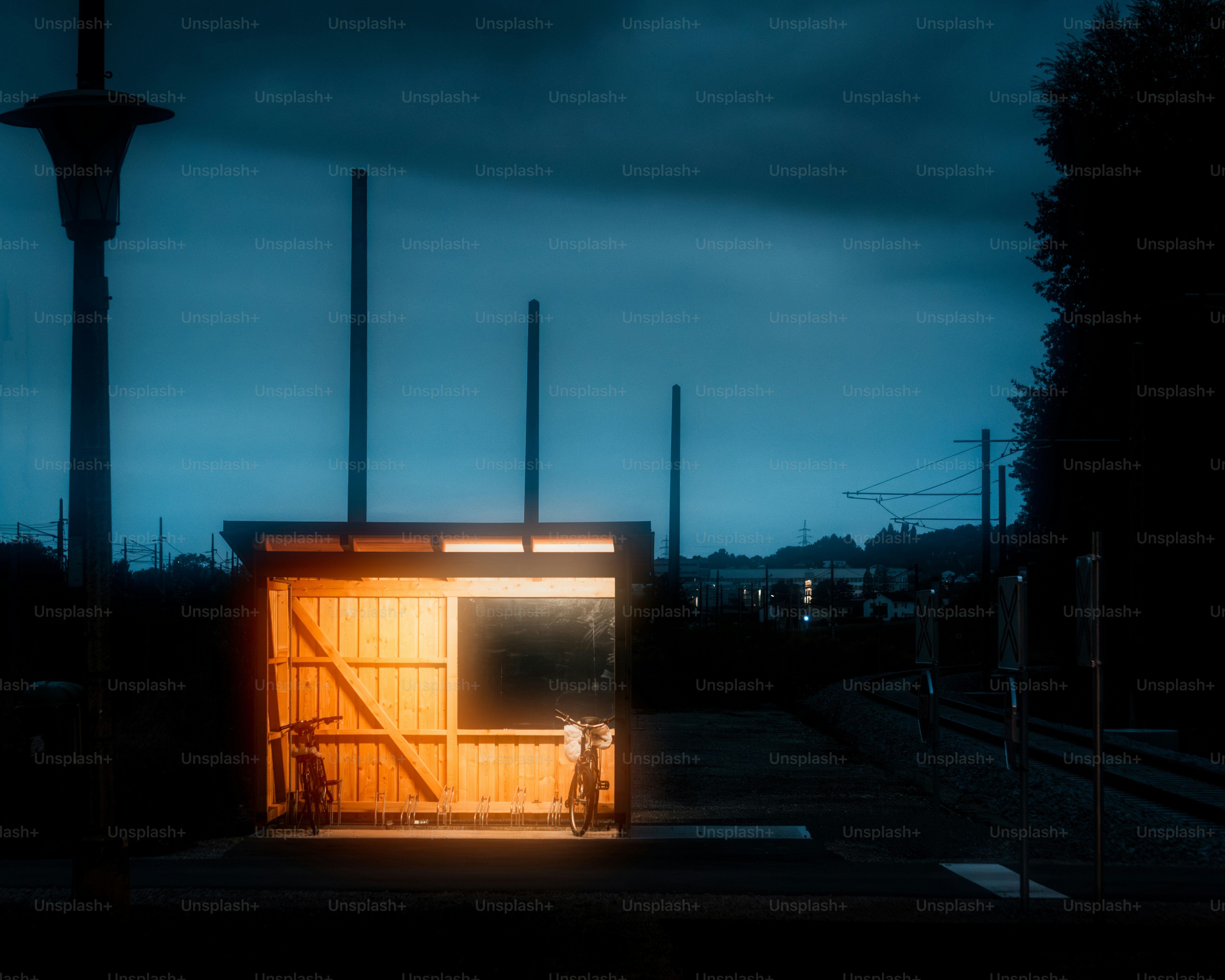 A small outhouse sitting on the side of a train track