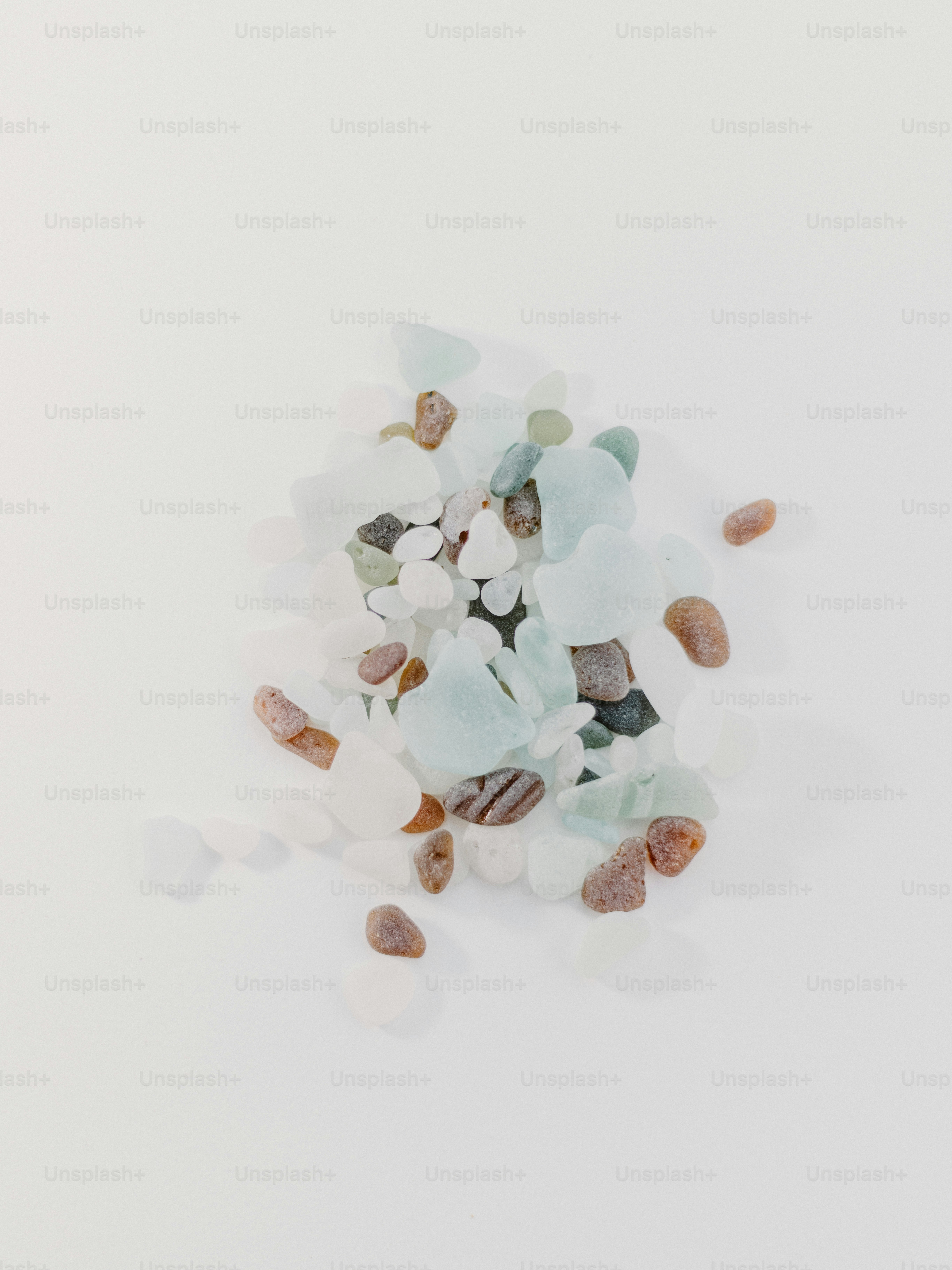 A pile of sea glass sitting on top of a white table