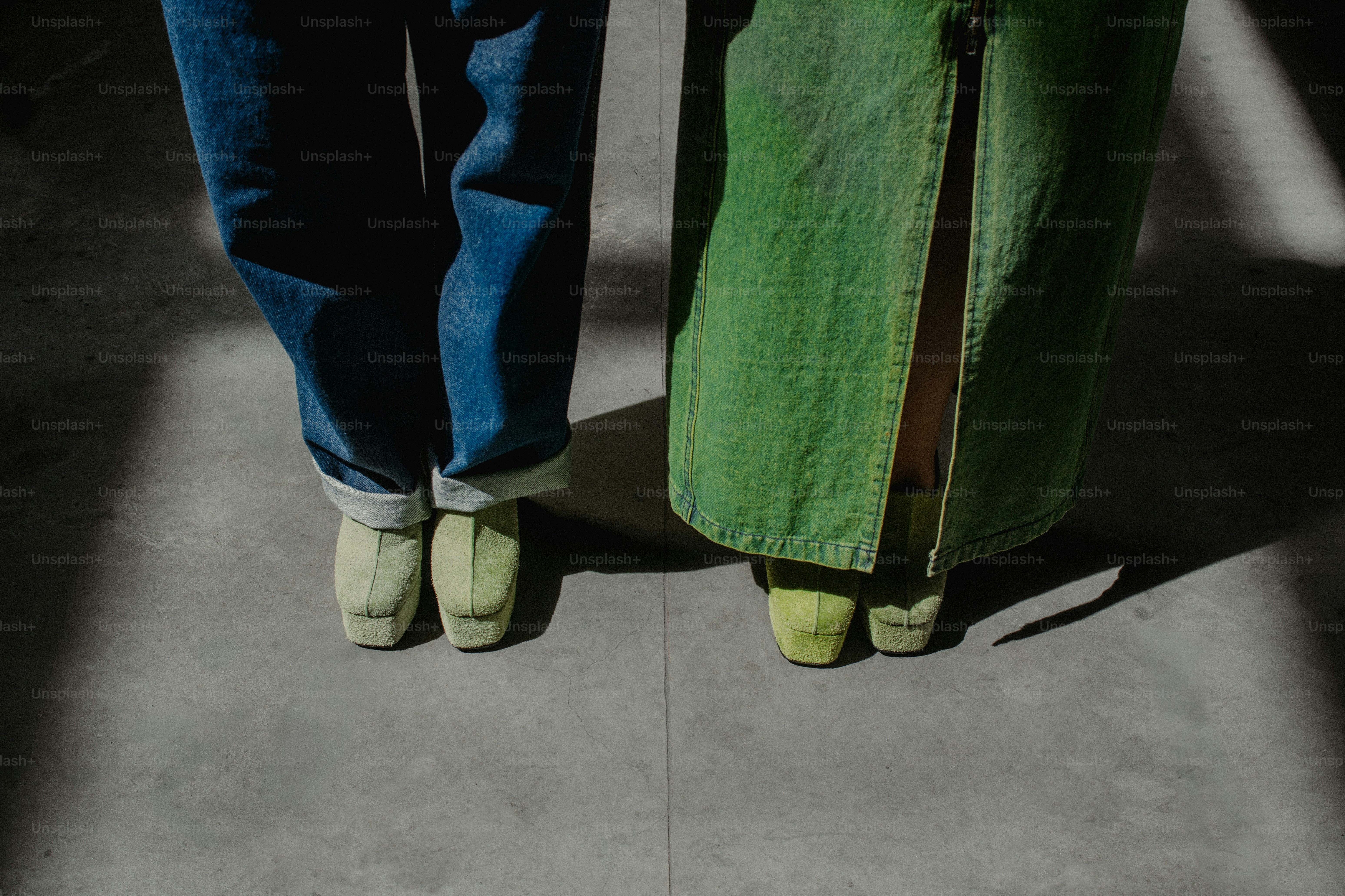 A person standing next to a green piece of luggage