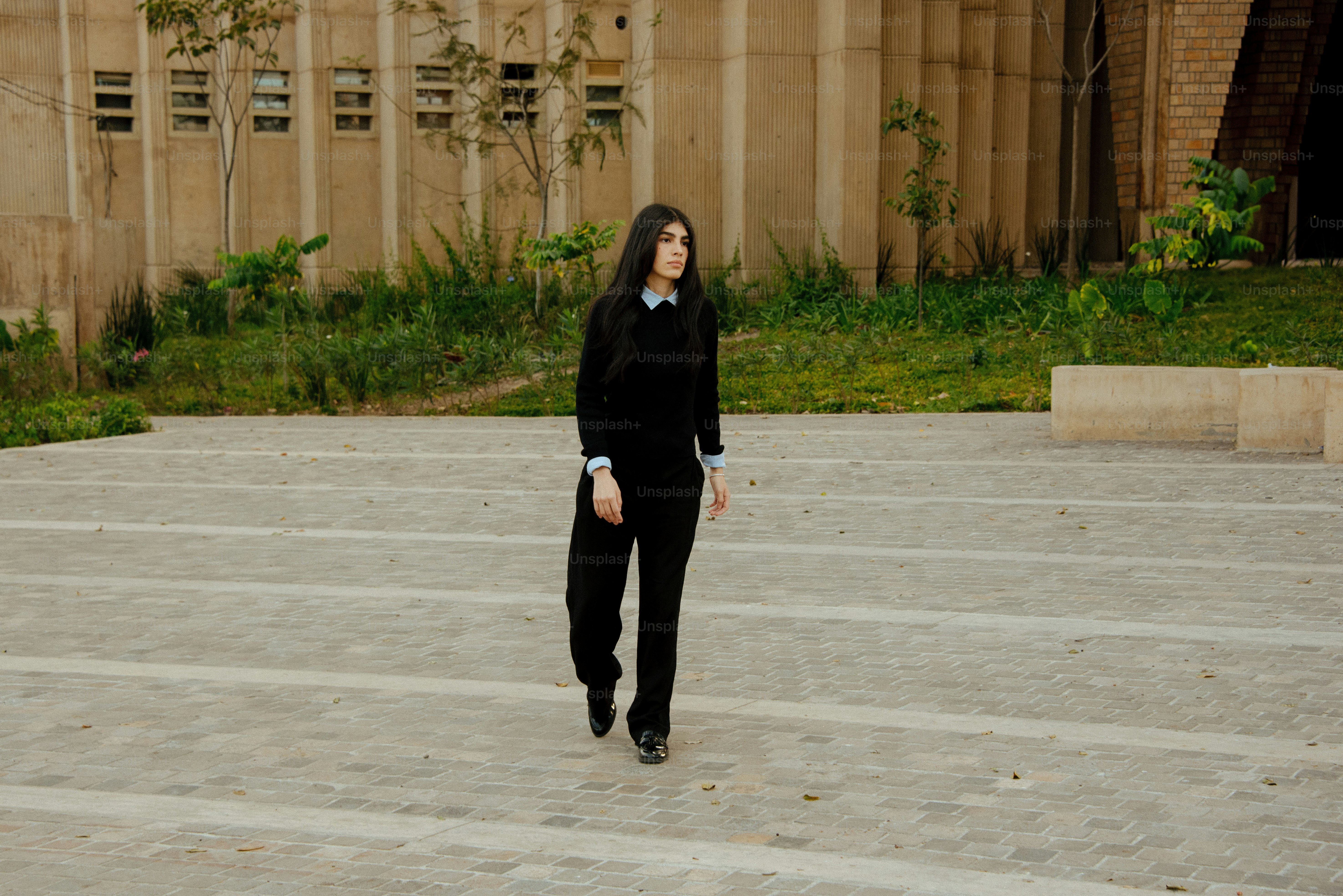 A woman in a black suit is walking down a set of steps