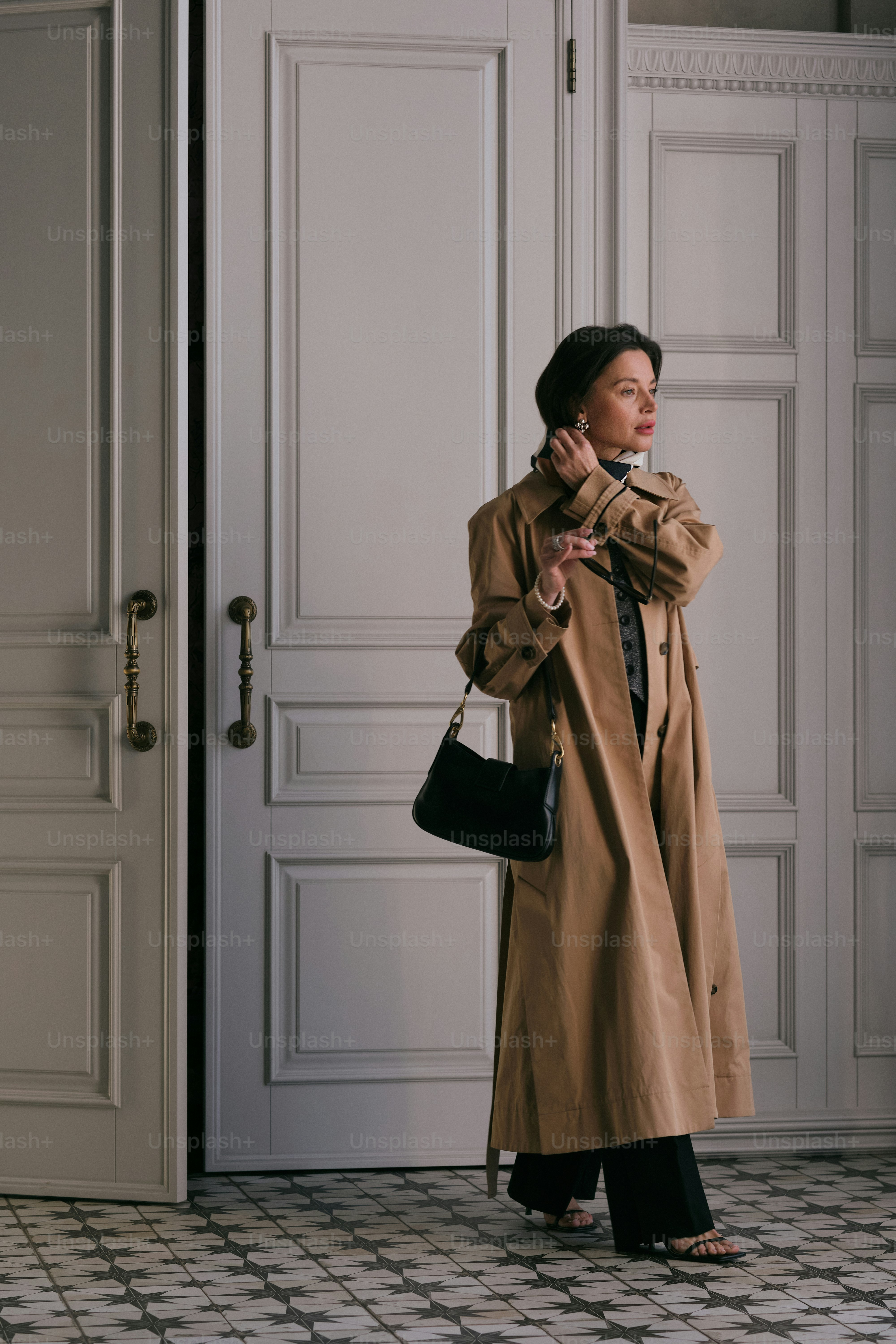 Una mujer parada frente a una puerta hablando por teléfono celular