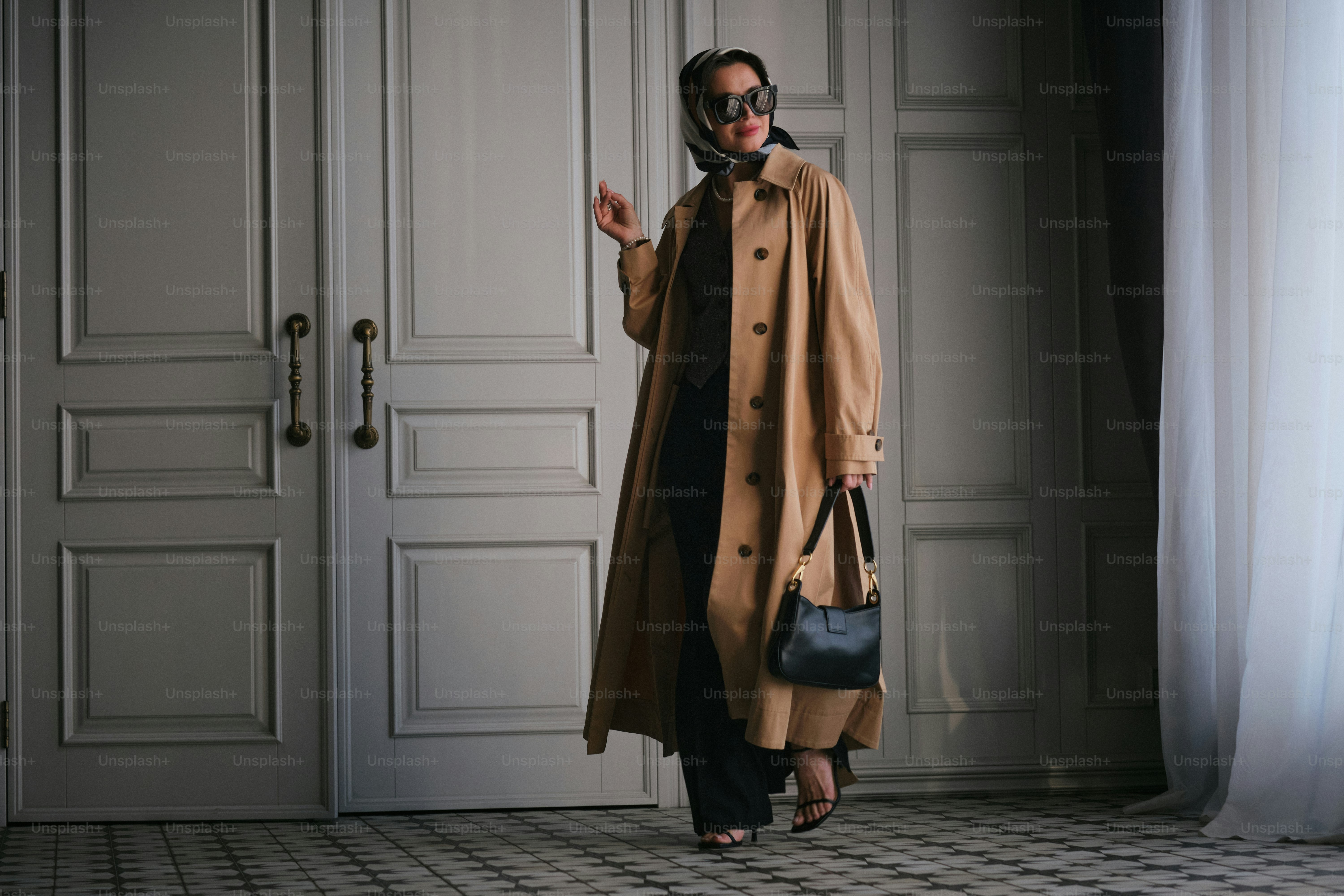 Una donna in piedi in una stanza con un cappotto addosso