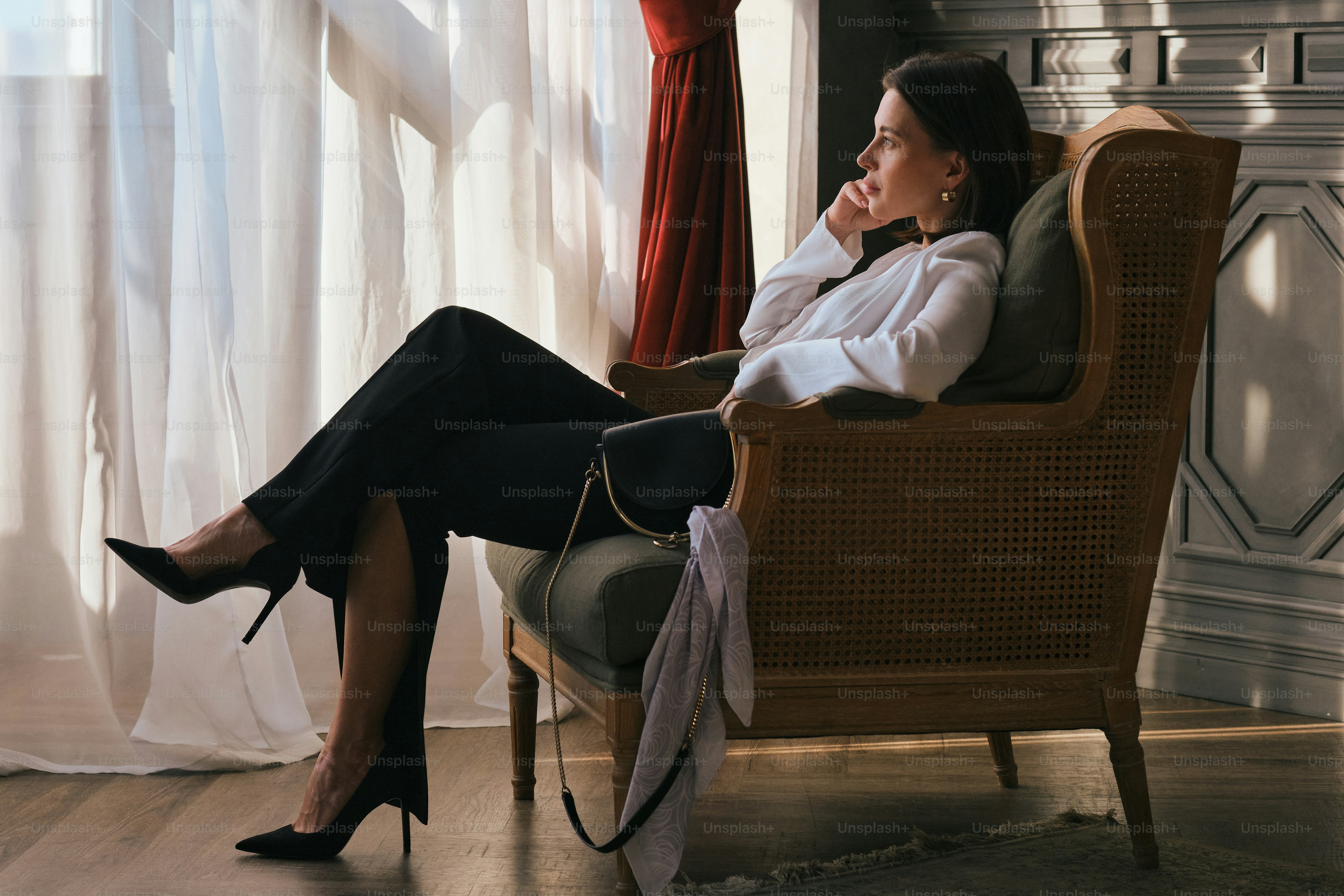 A woman sitting in a chair in front of a window