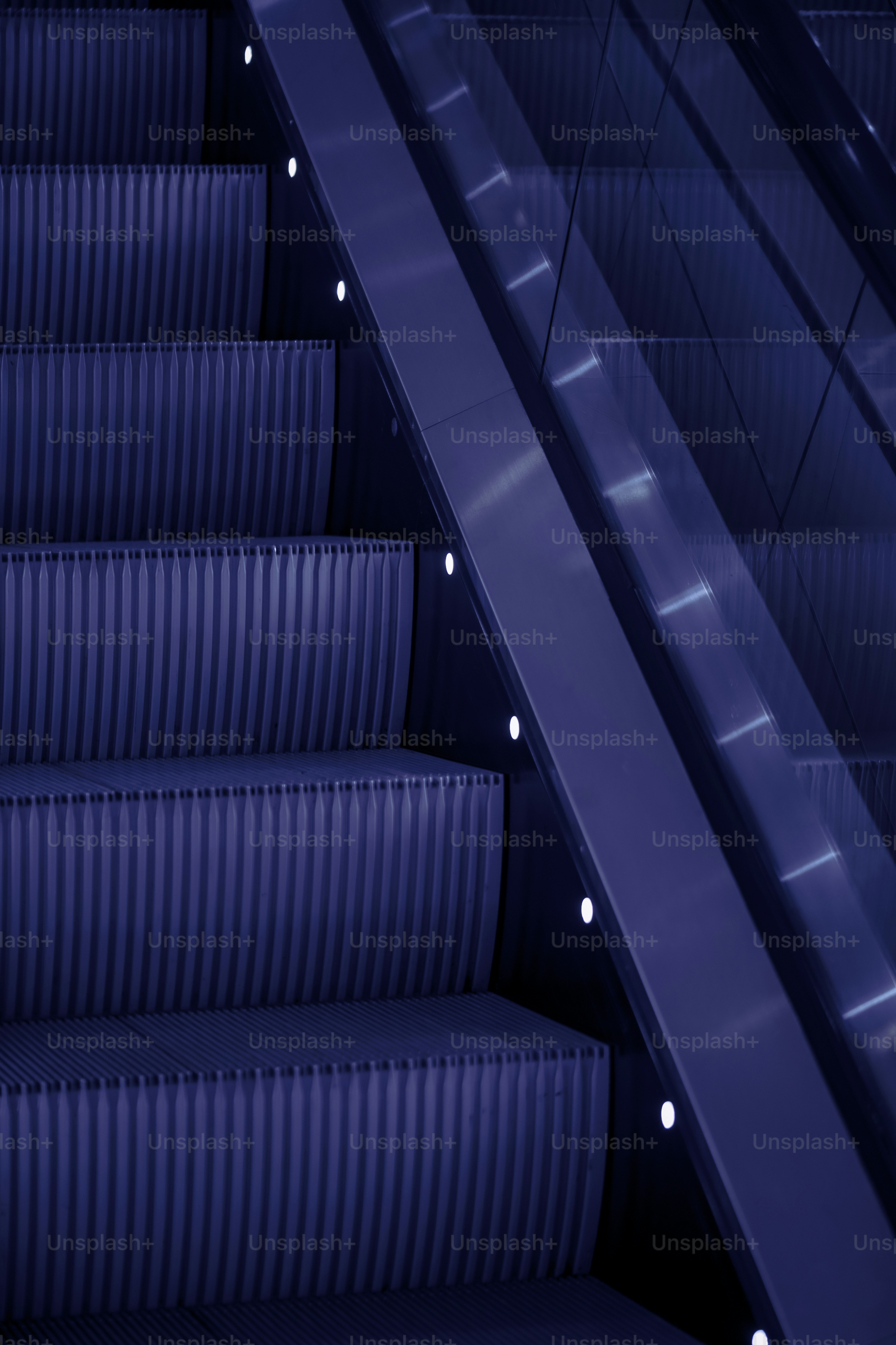 Eine Rolltreppe mit blauen Sitzen neben einer Treppe
