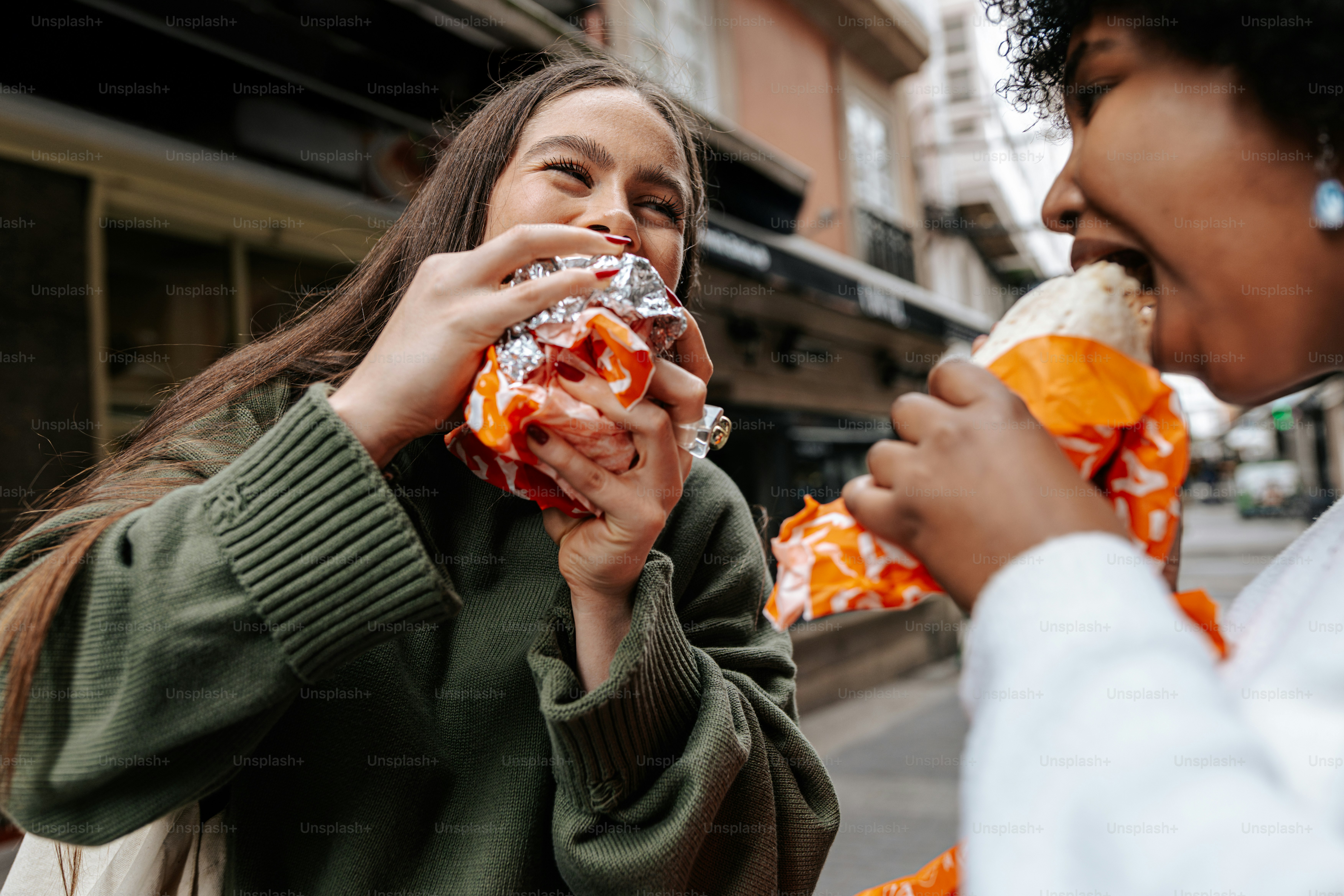 Ein paar Frauen, die nebeneinander stehen und essen