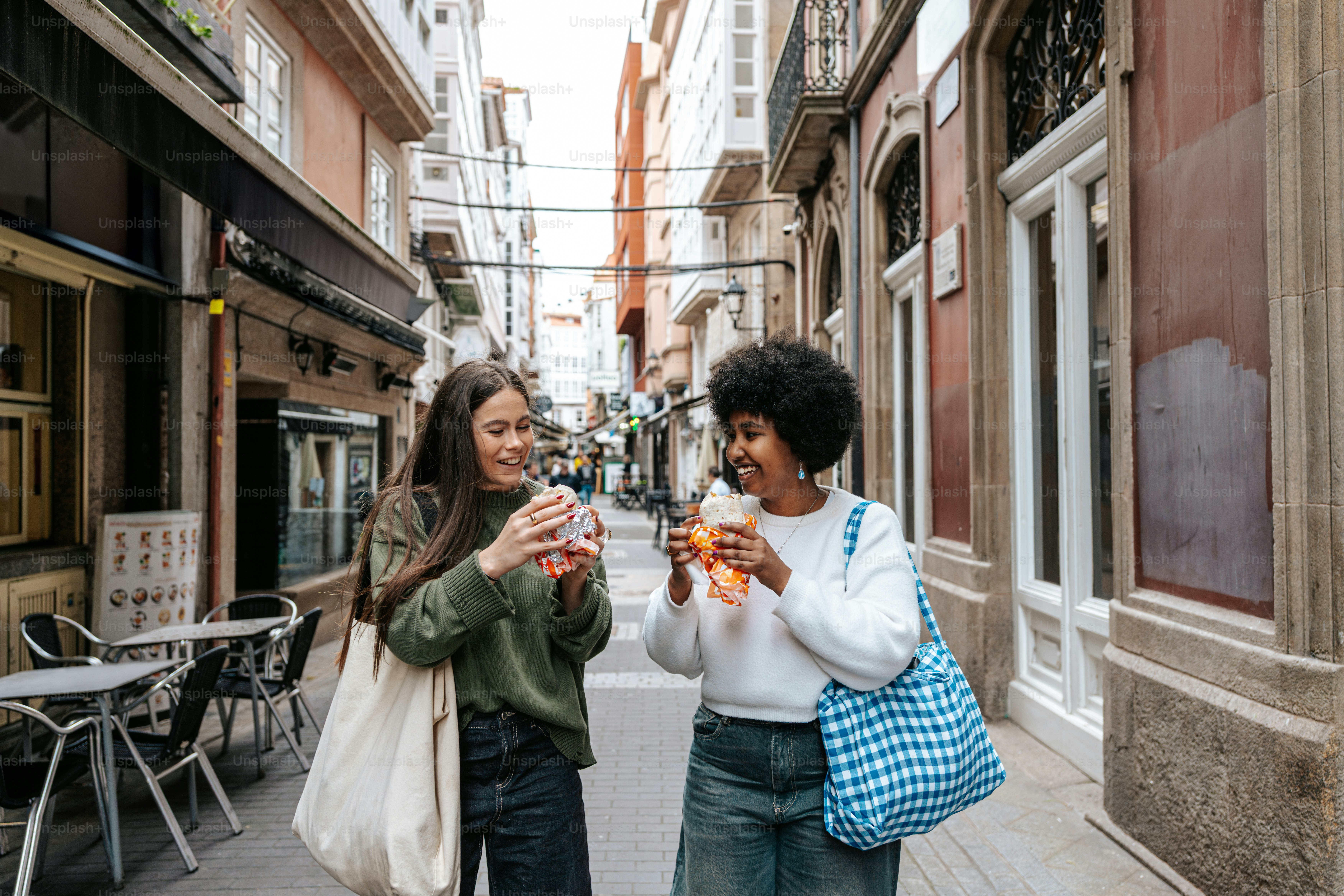 A couple of women standing next to each other on a street