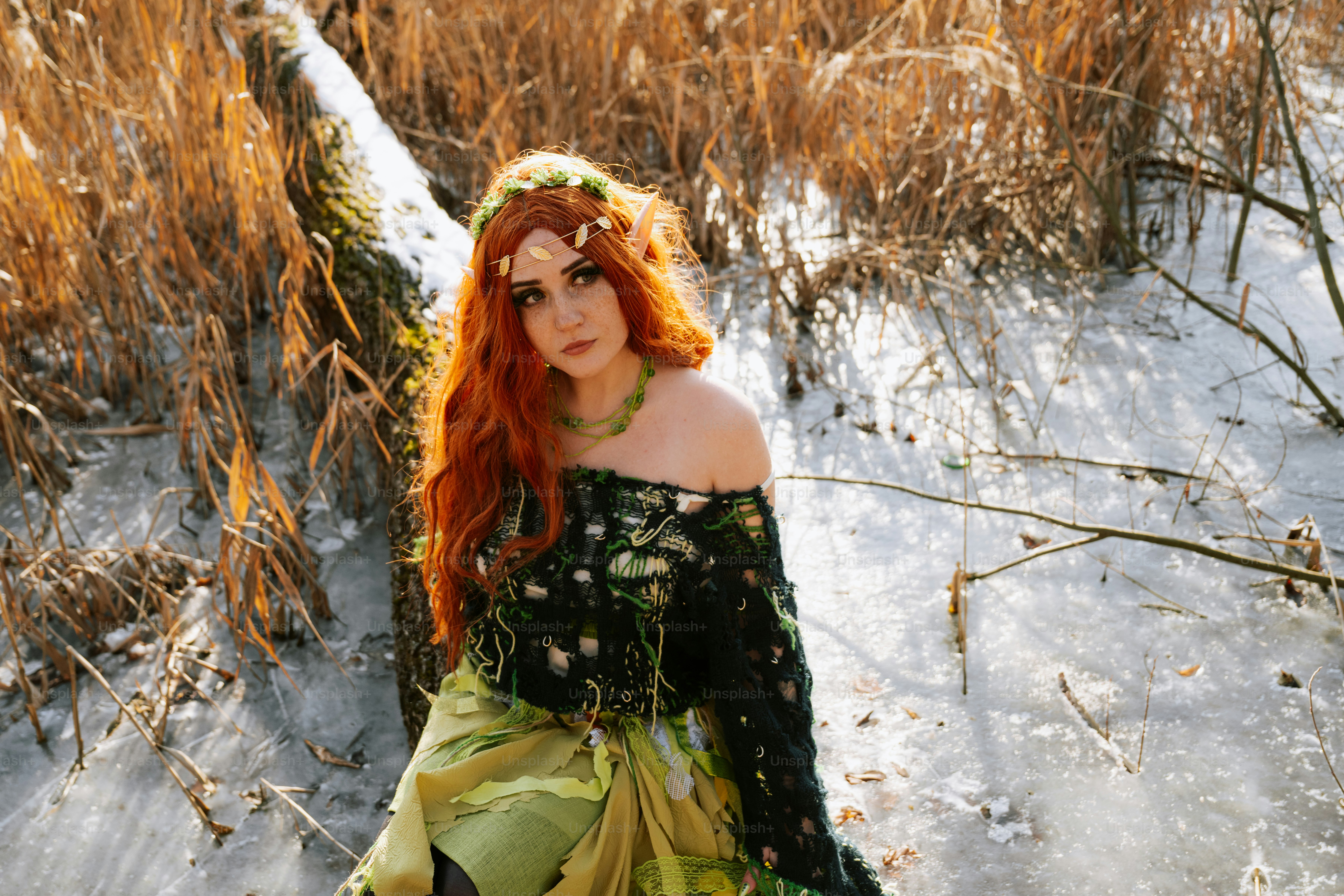 Une femme aux cheveux roux est assise dans la neige