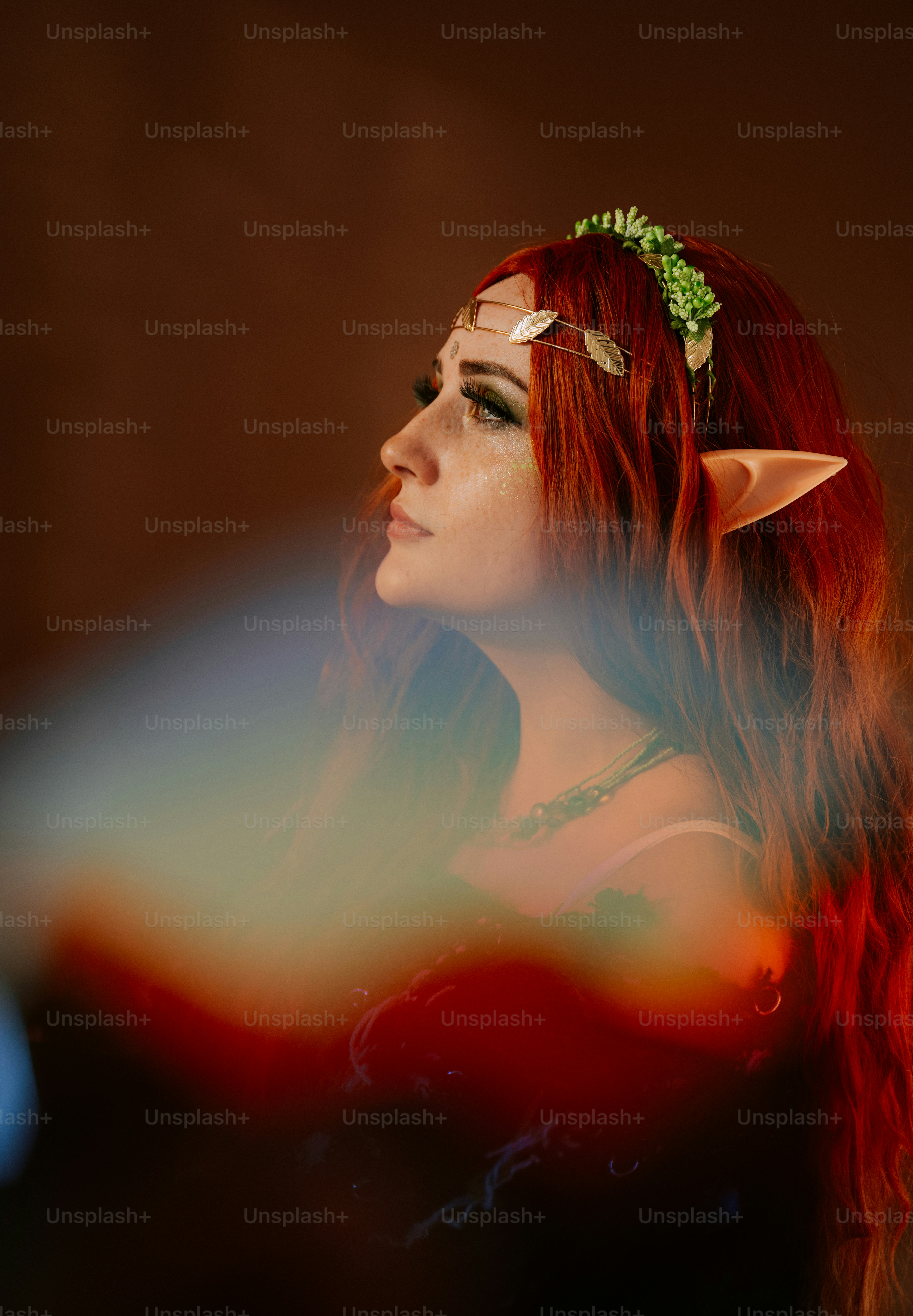 Une femme aux cheveux roux et une fleur verte dans les cheveux