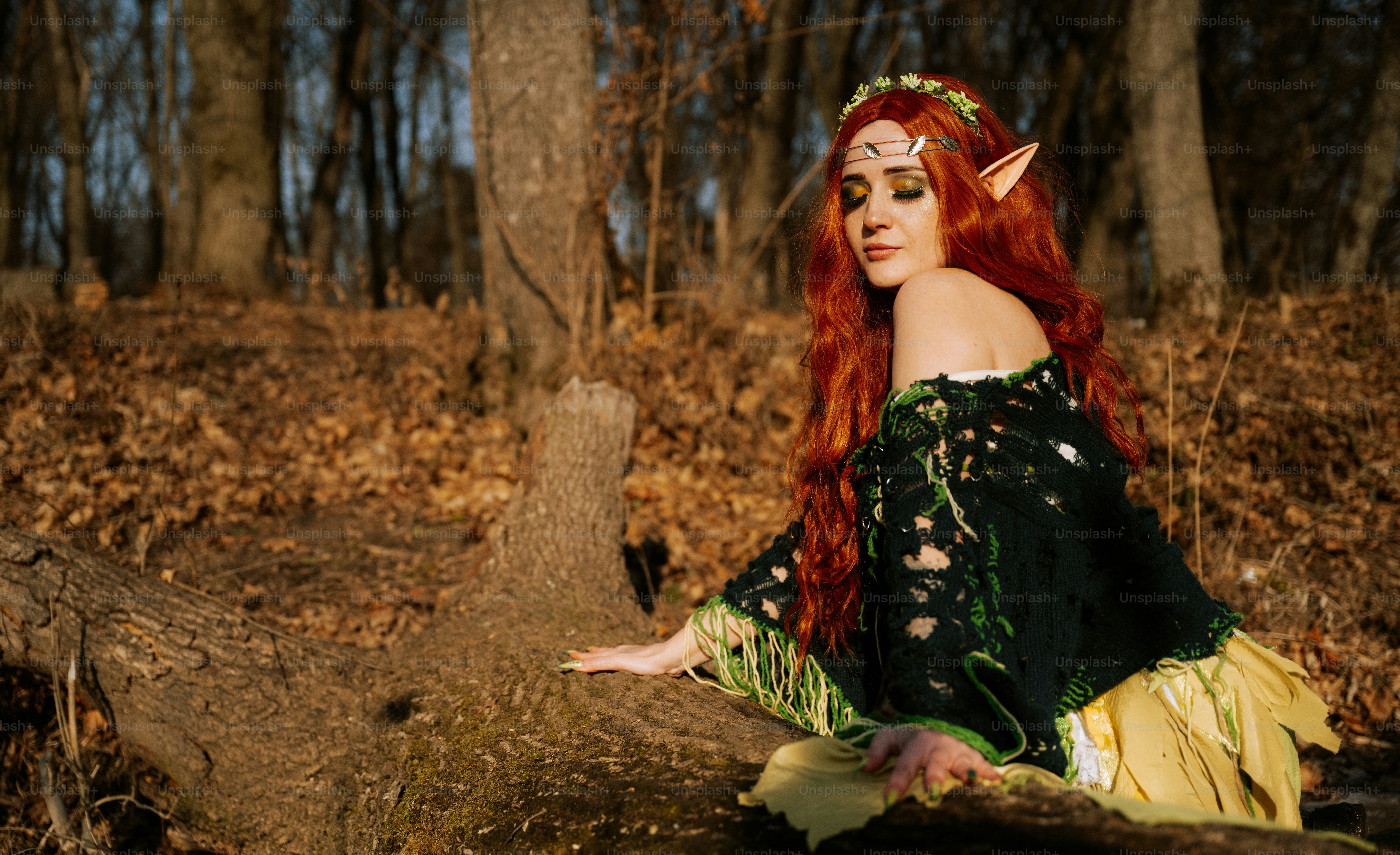 A woman with red hair sitting on a log in the woods