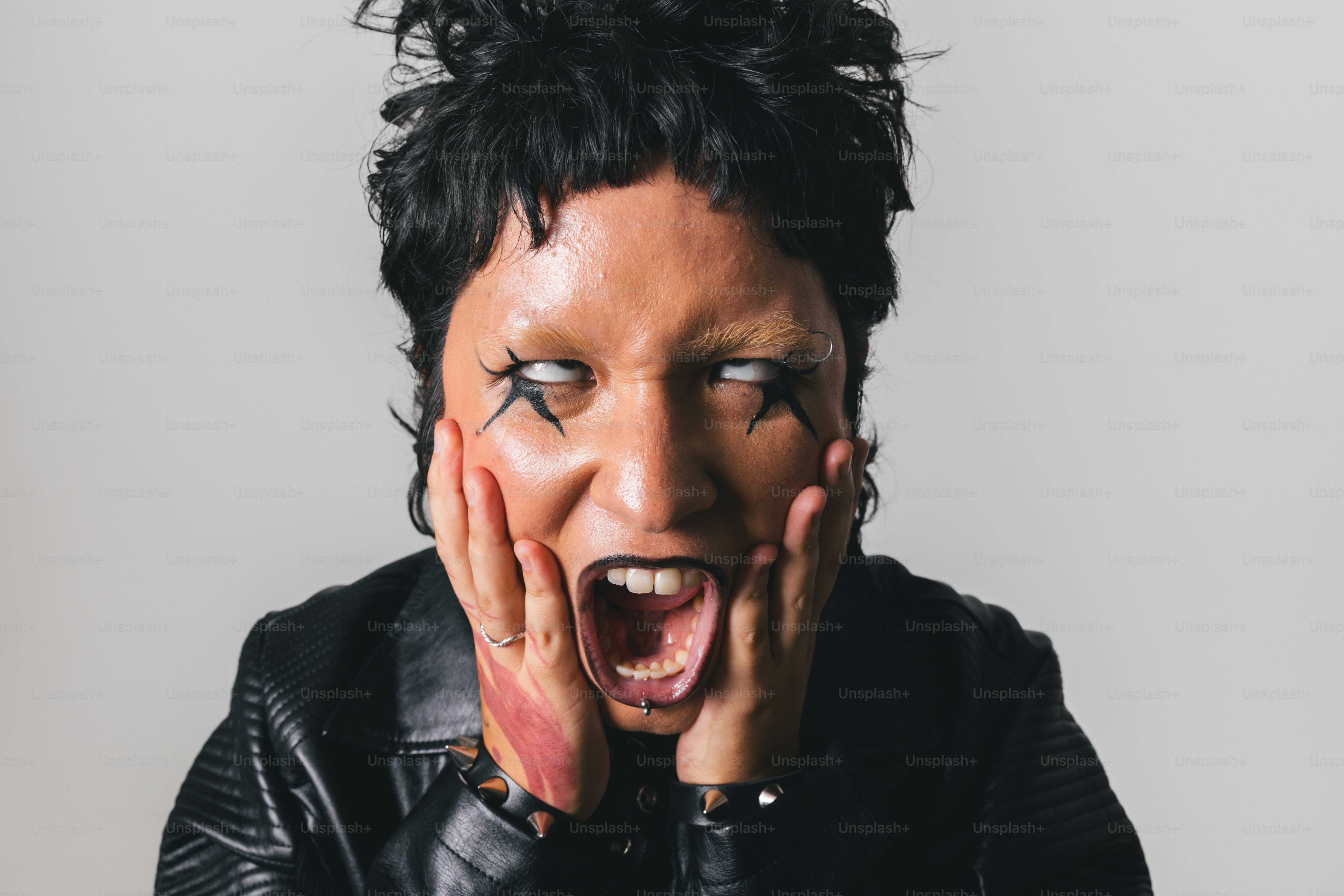 Eine Frau mit offenem Mund und den Händen vor dem Gesicht