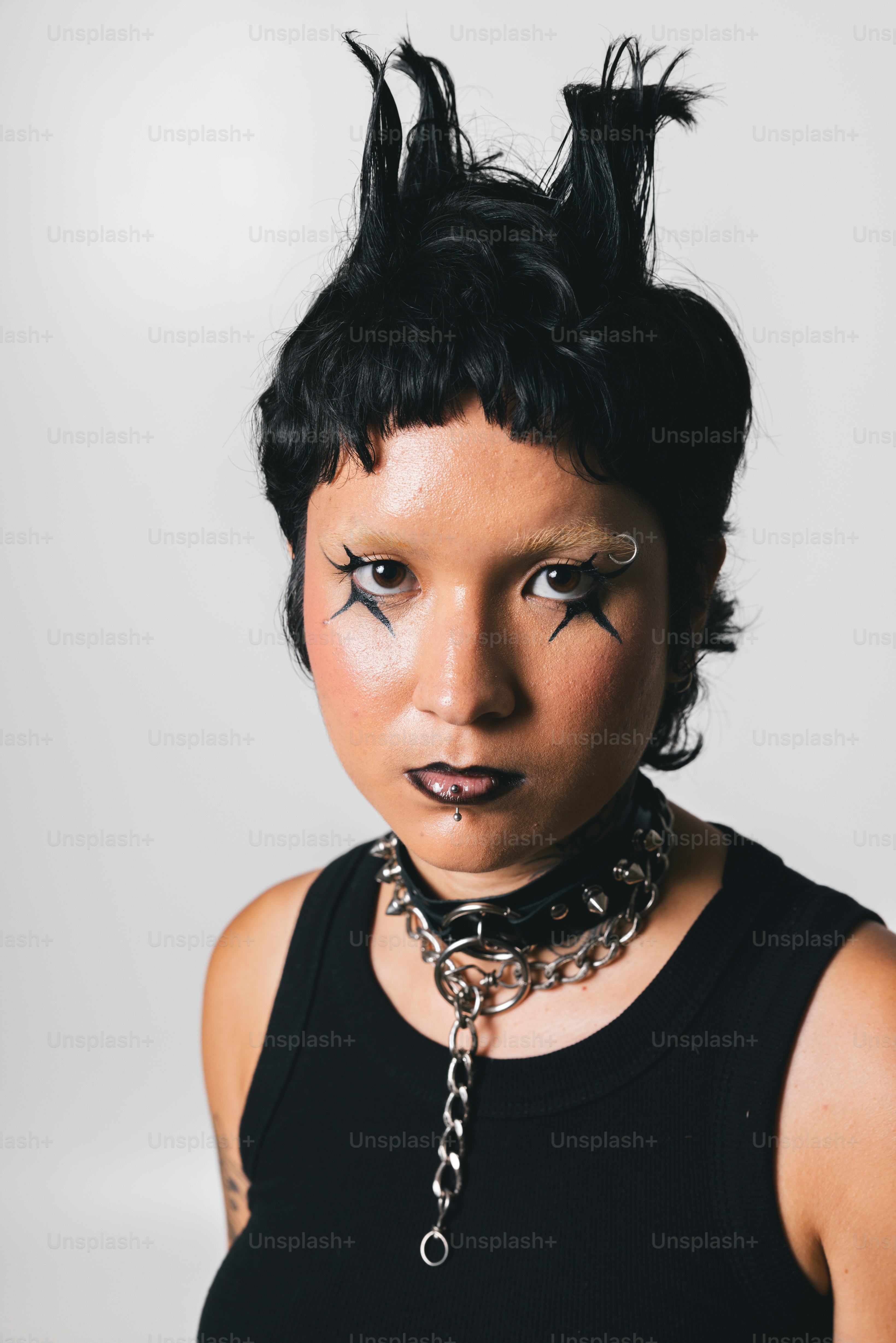 Una mujer con el pelo negro y piercings en la cara