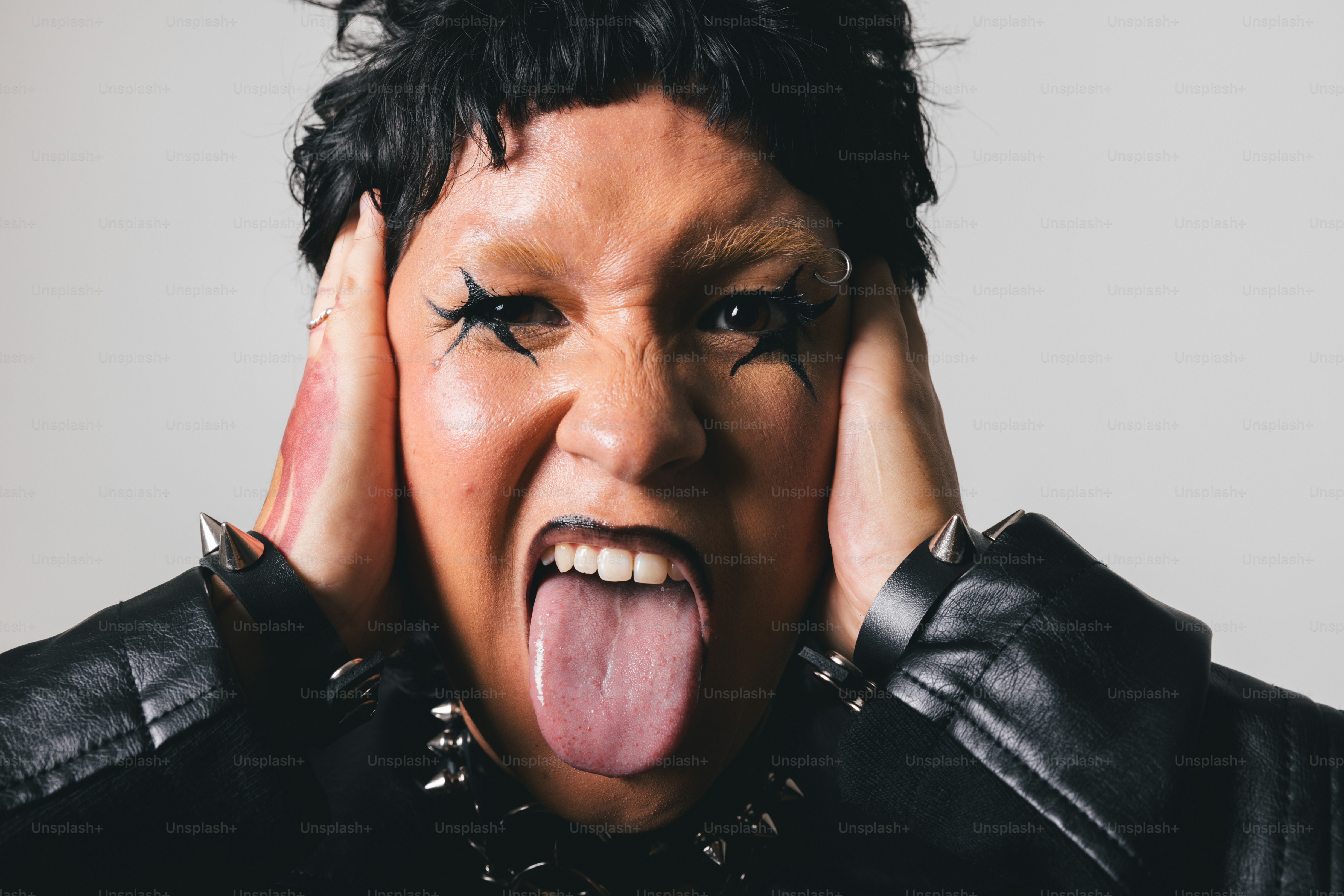 A woman sticking her tongue out with her hands