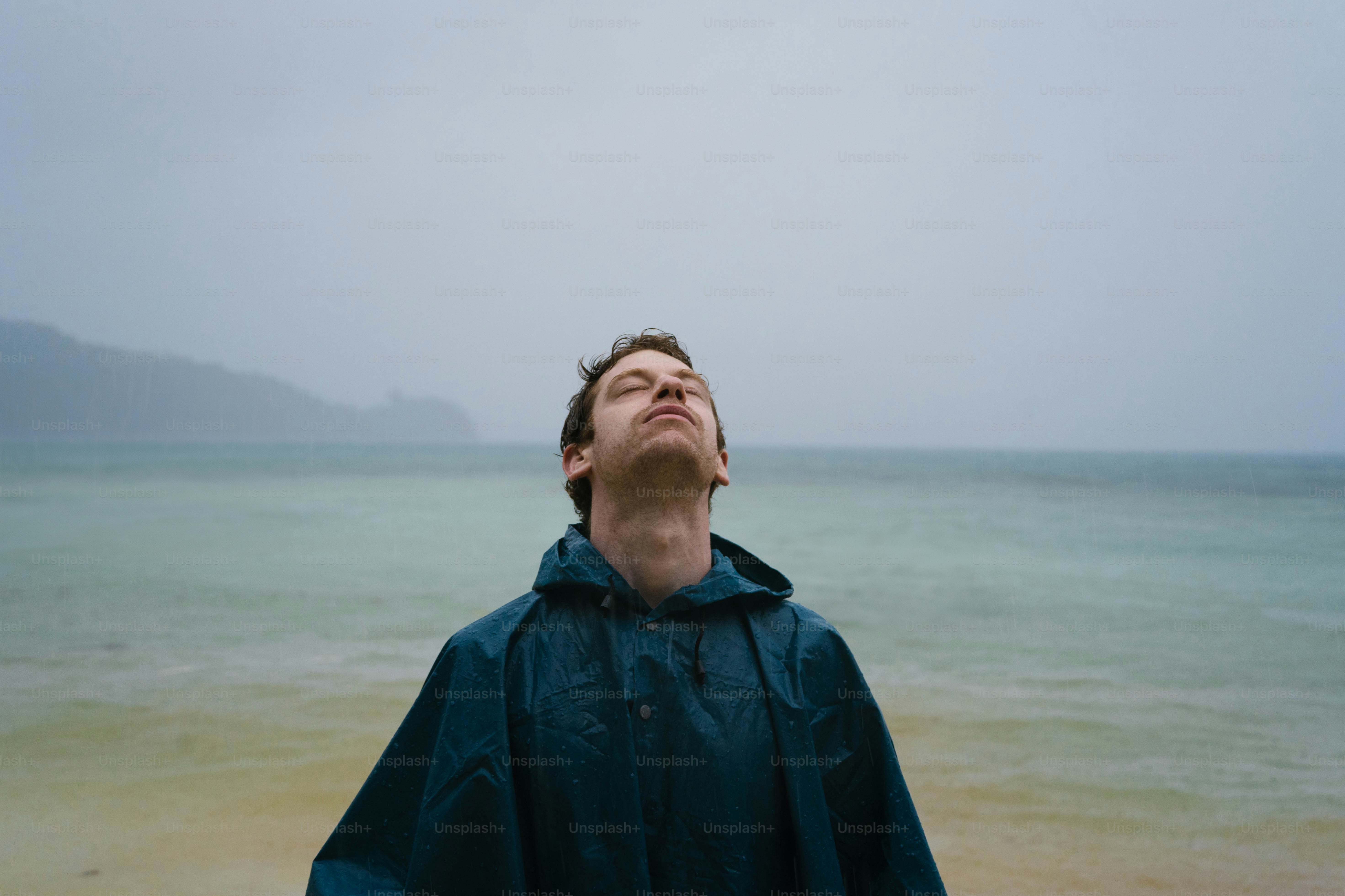 A man standing on a beach looking up into the sky