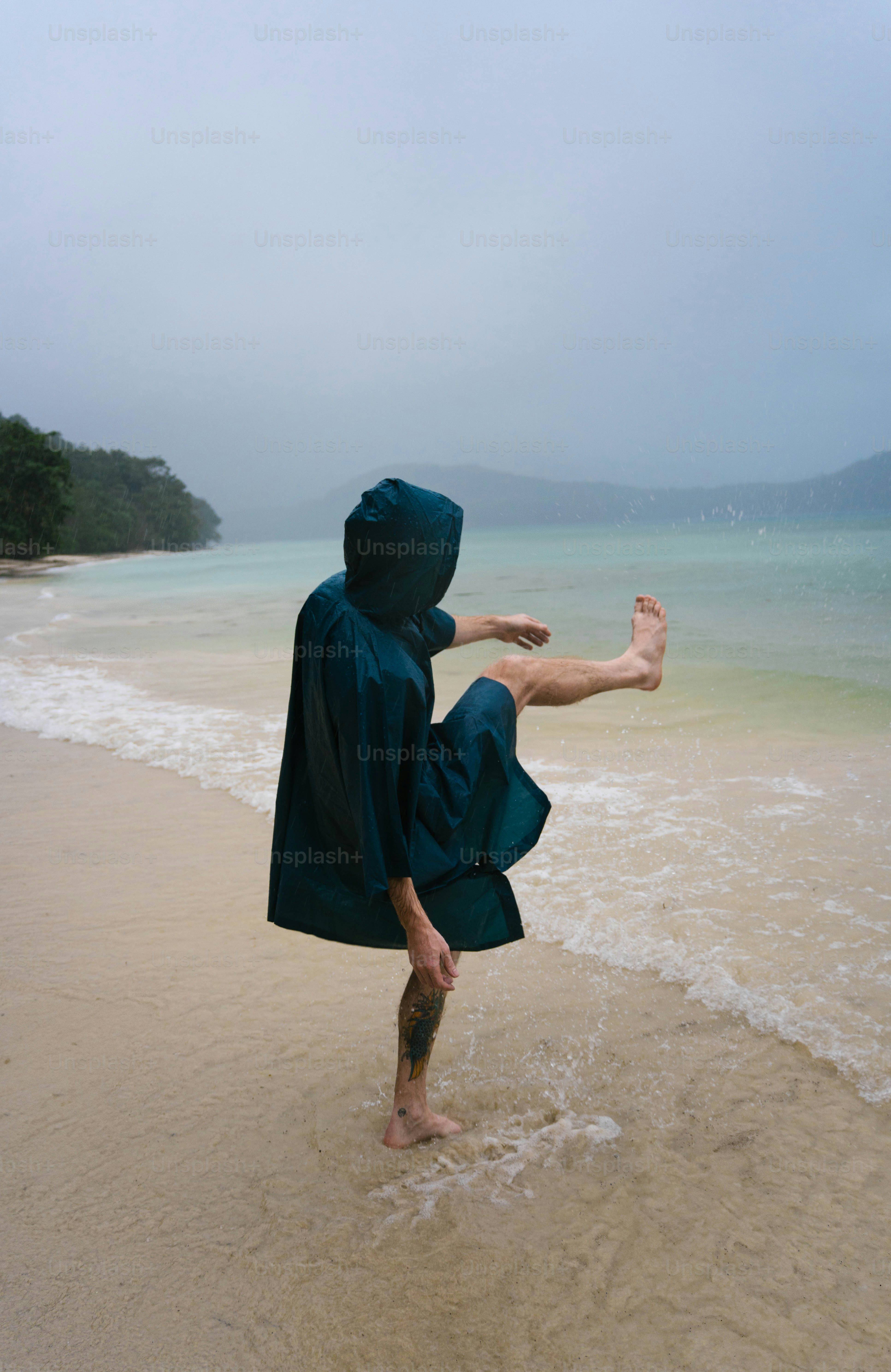 Eine Person in einem blauen Gewand, die an einem Strand steht