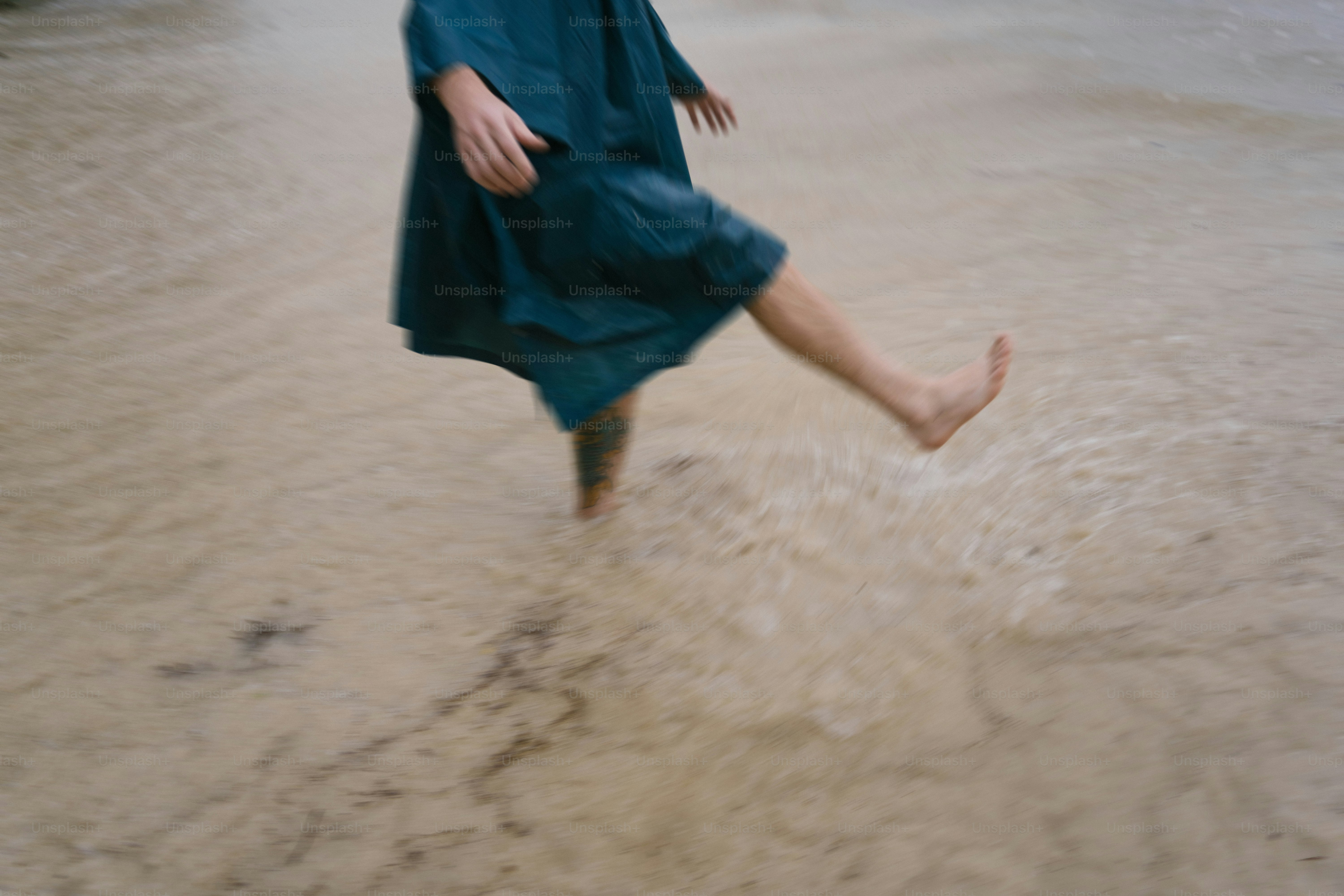 Eine Frau in einem blauen Kleid läuft im Wasser