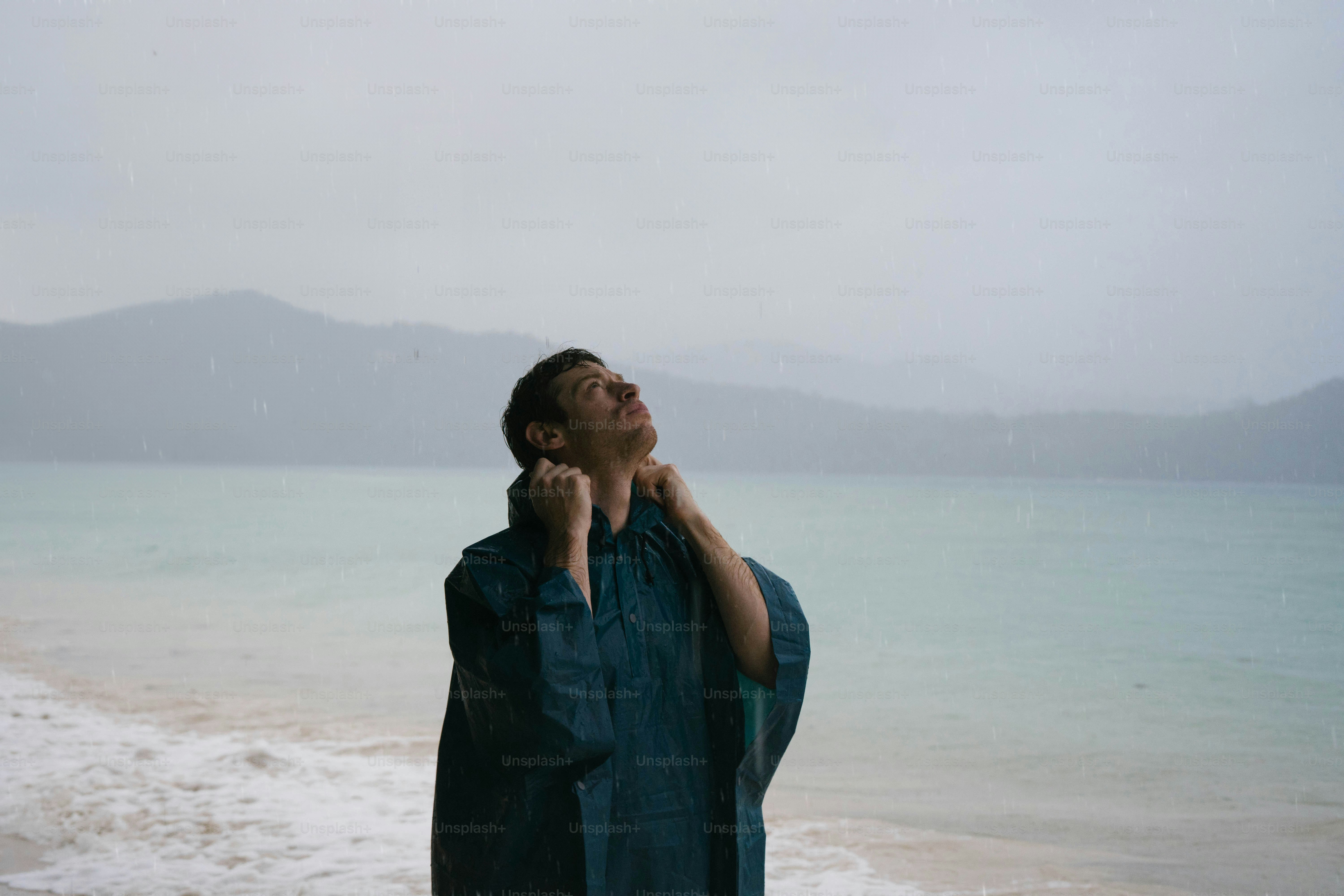 A man standing on a beach next to the ocean