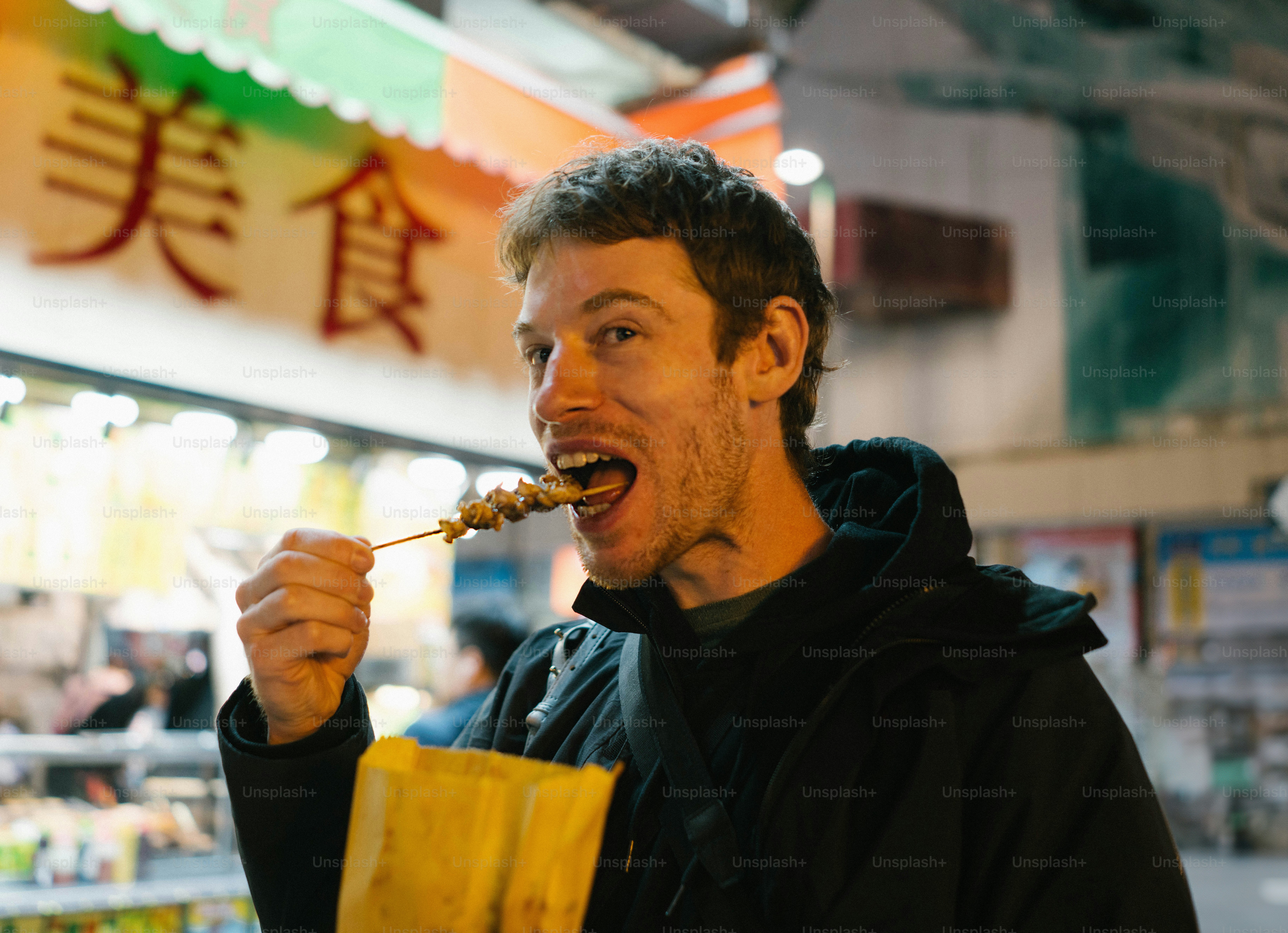 A man eating a bag of food in a store