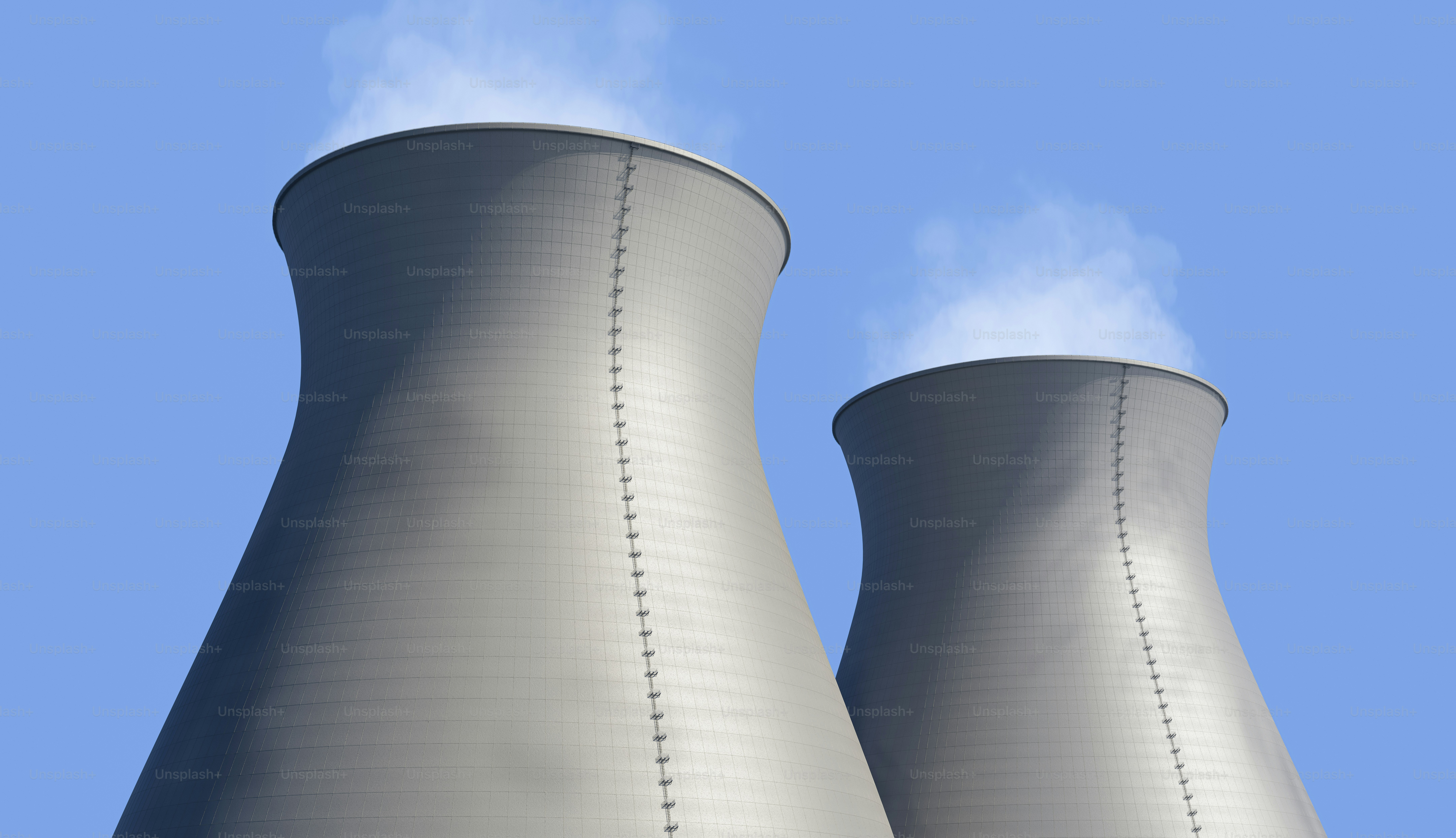 Two cooling towers with smoke coming out of them