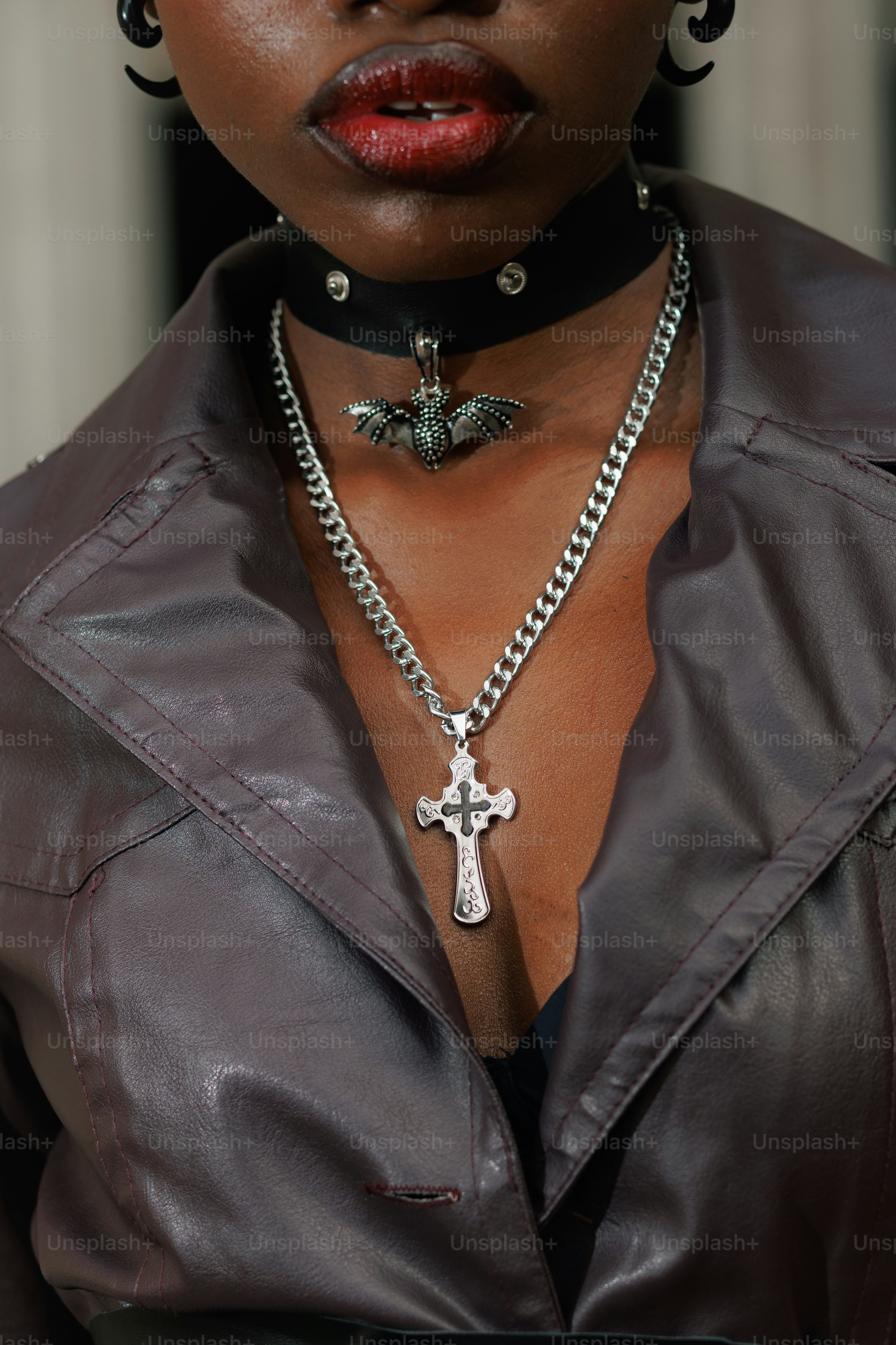 A woman wearing a leather jacket and a cross necklace