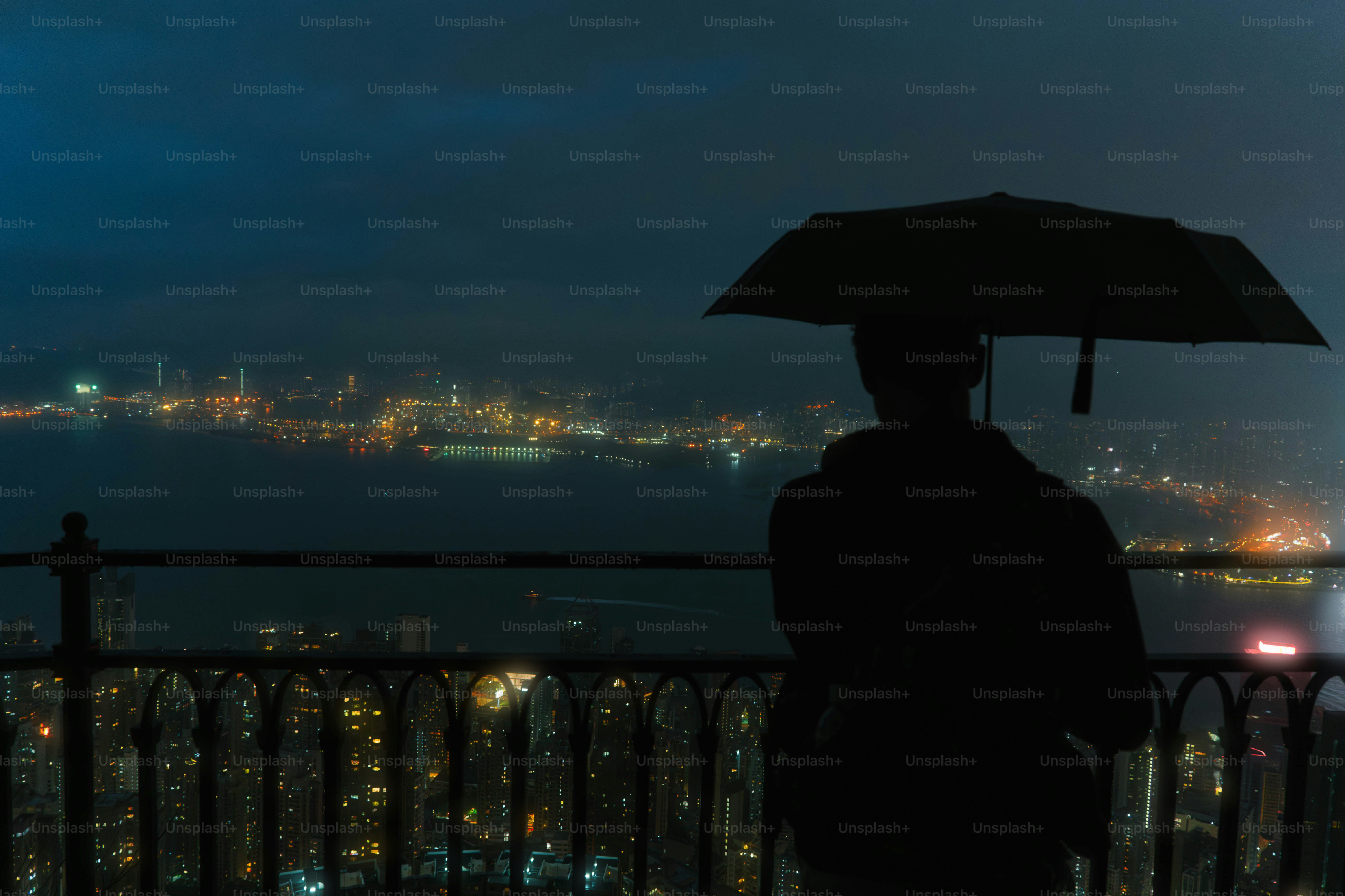 A person standing under an umbrella at night