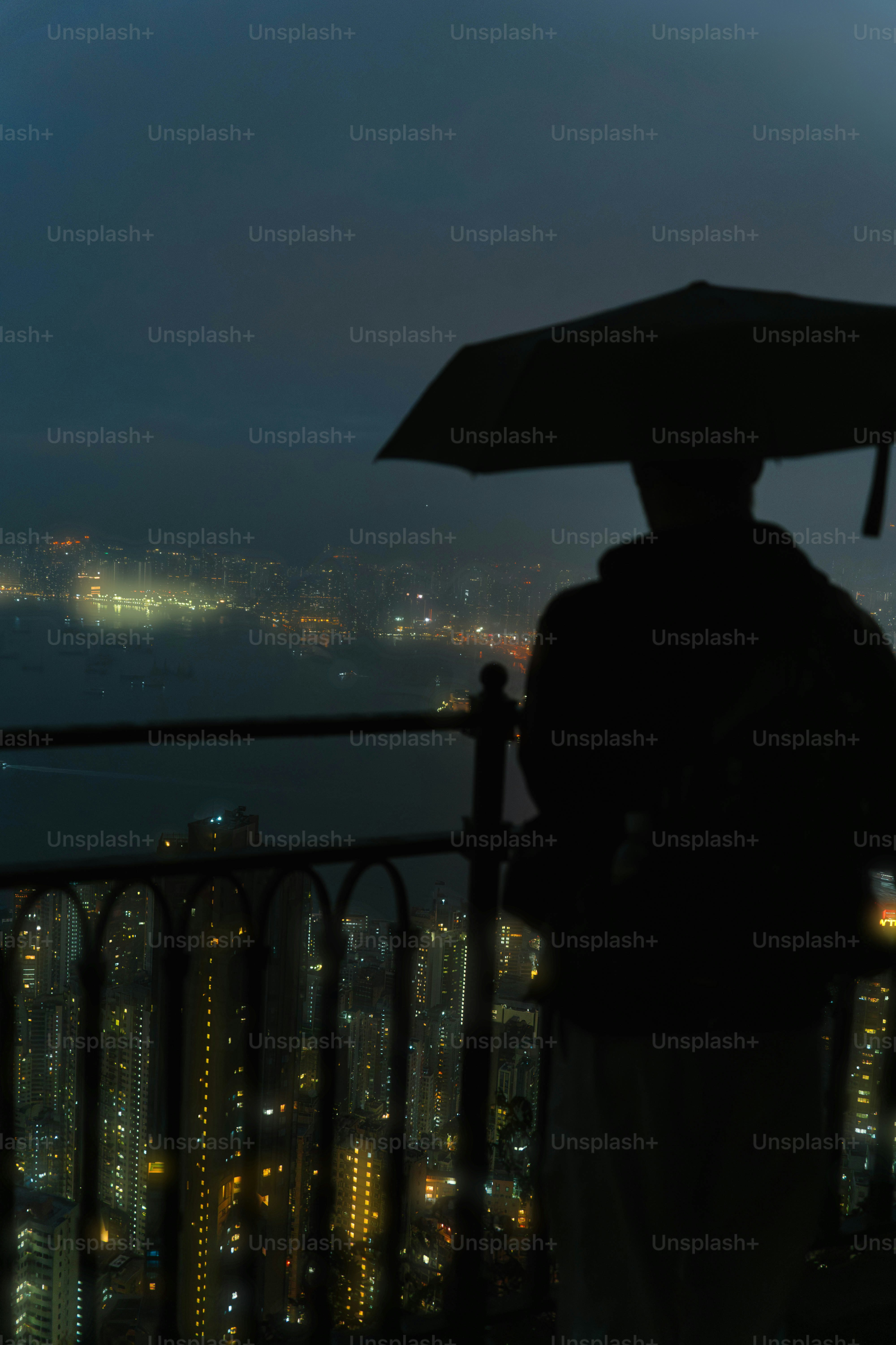 A person with an umbrella standing on a balcony