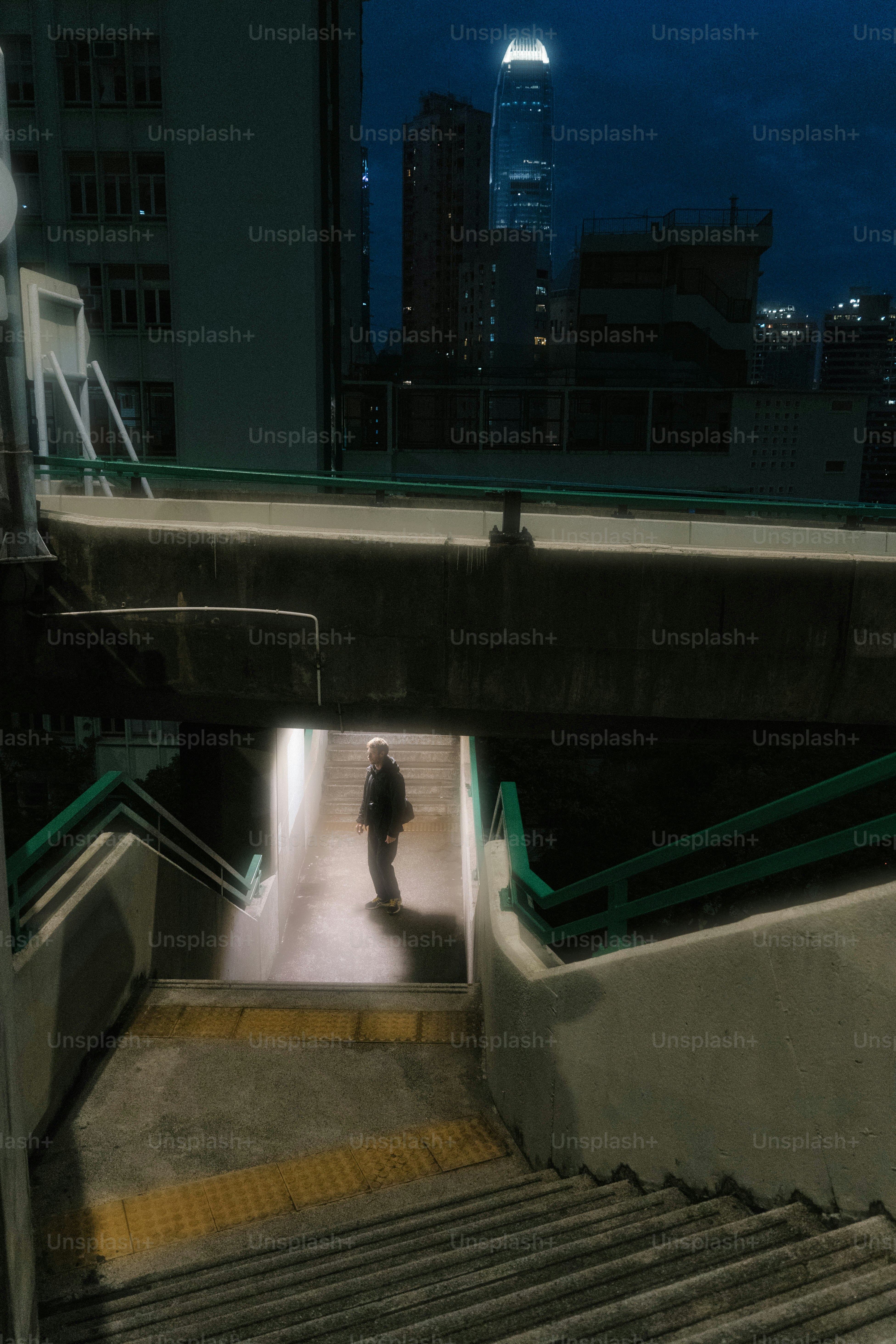 A man walking up a flight of stairs at night