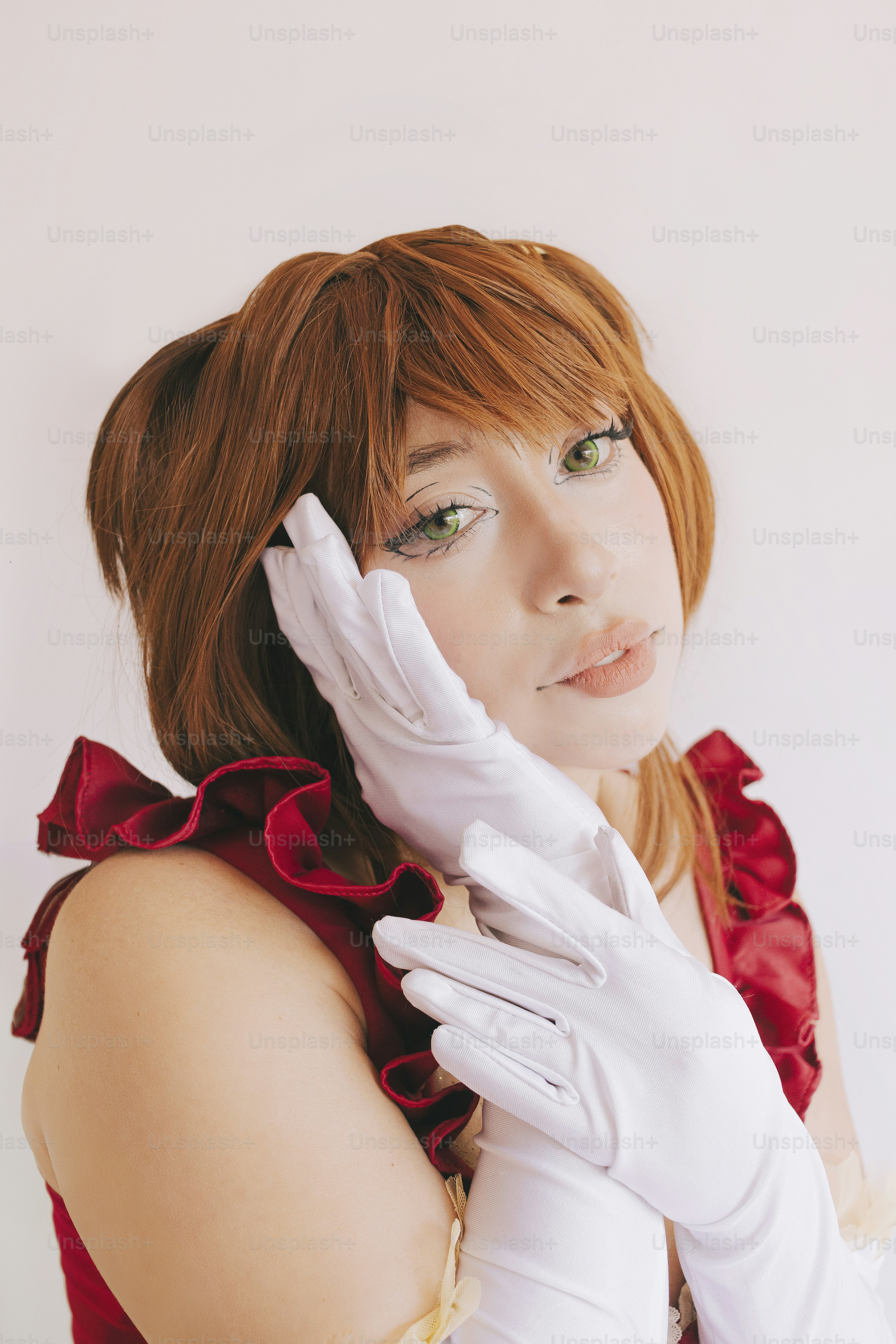 Seorang wanita bercosplay berpose dengan ekspresi manis.