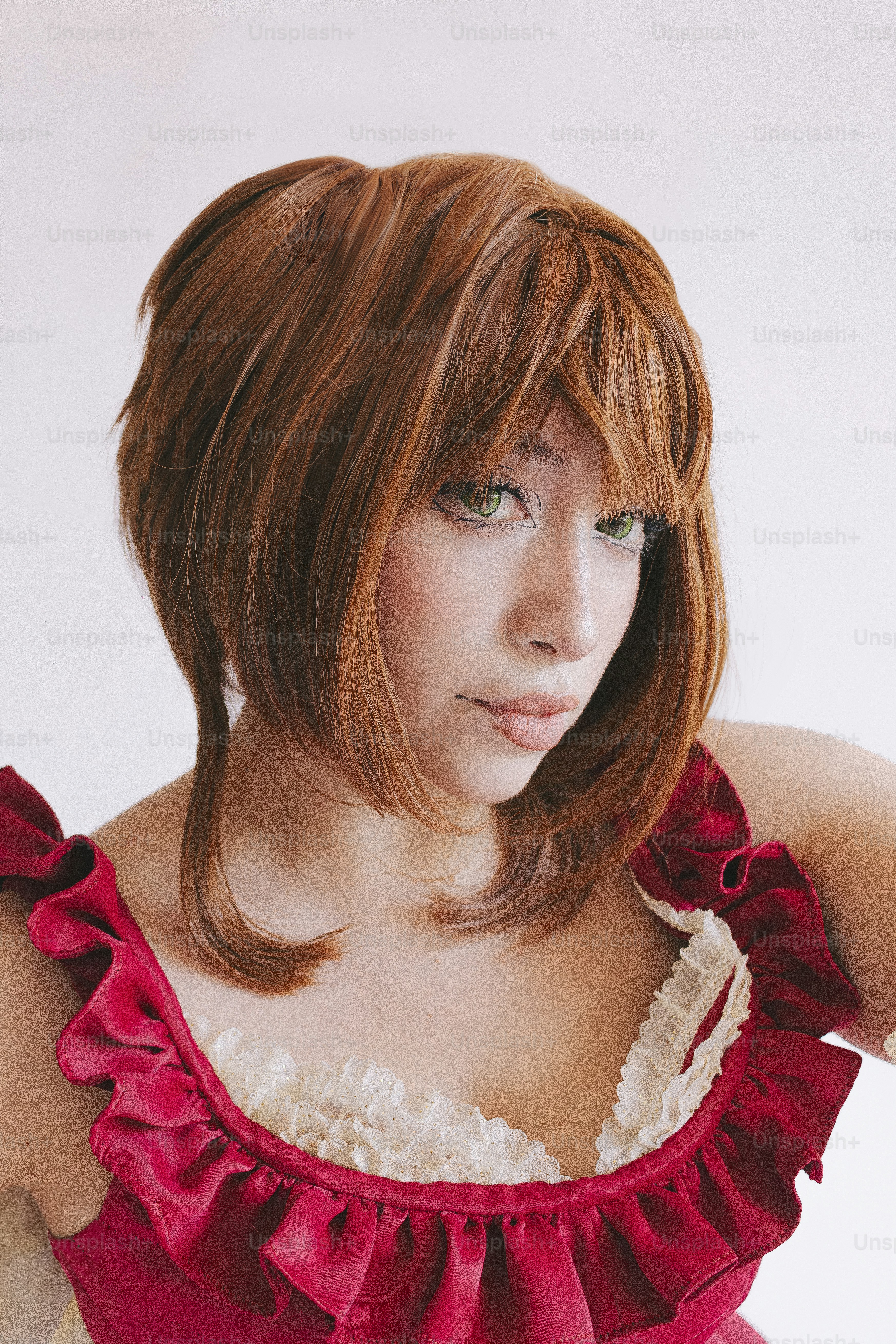 Seorang wanita berpakaian merah dan berpose wig.