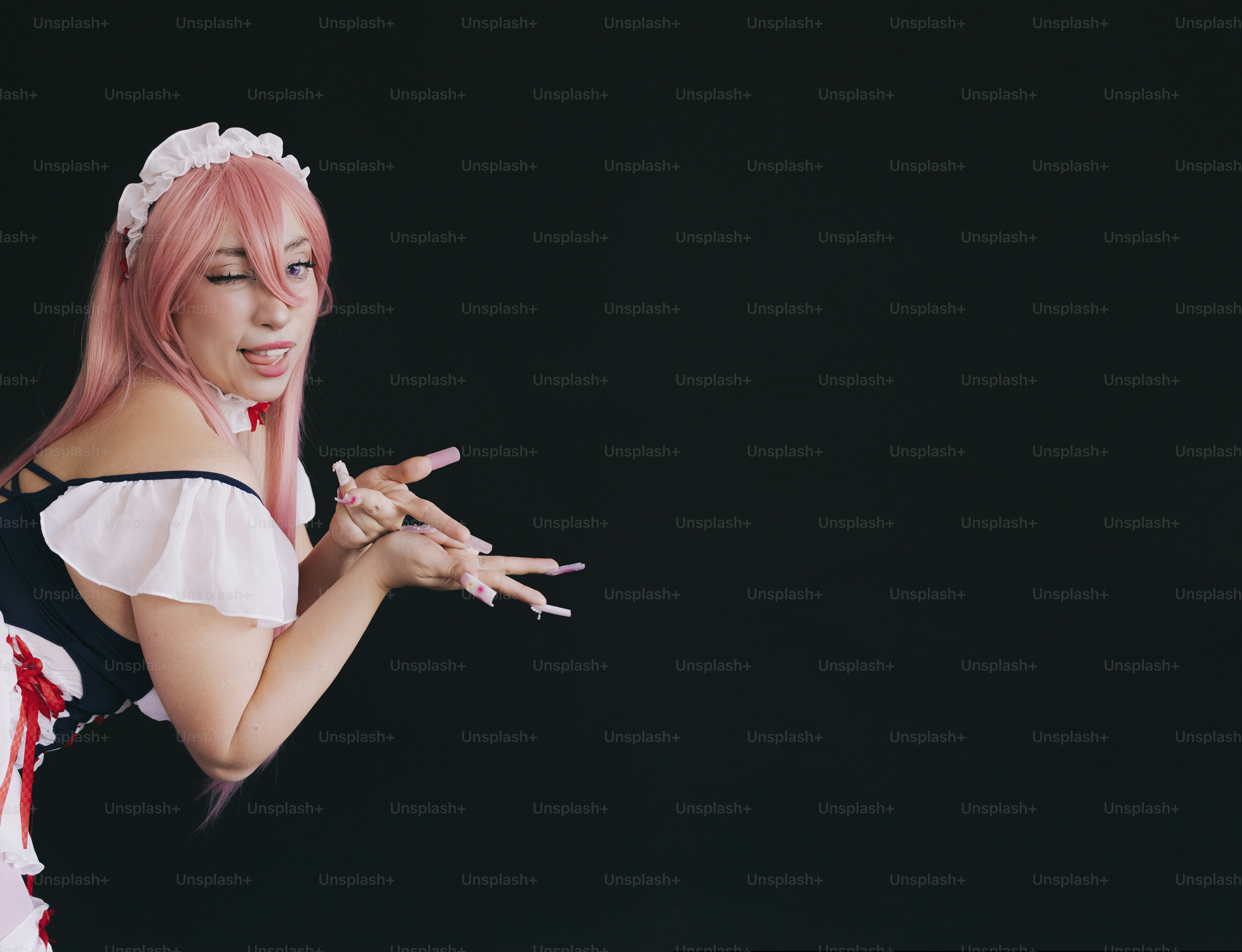 Cosplayer berpakaian seperti pelayan mengedipkan mata ke kamera.