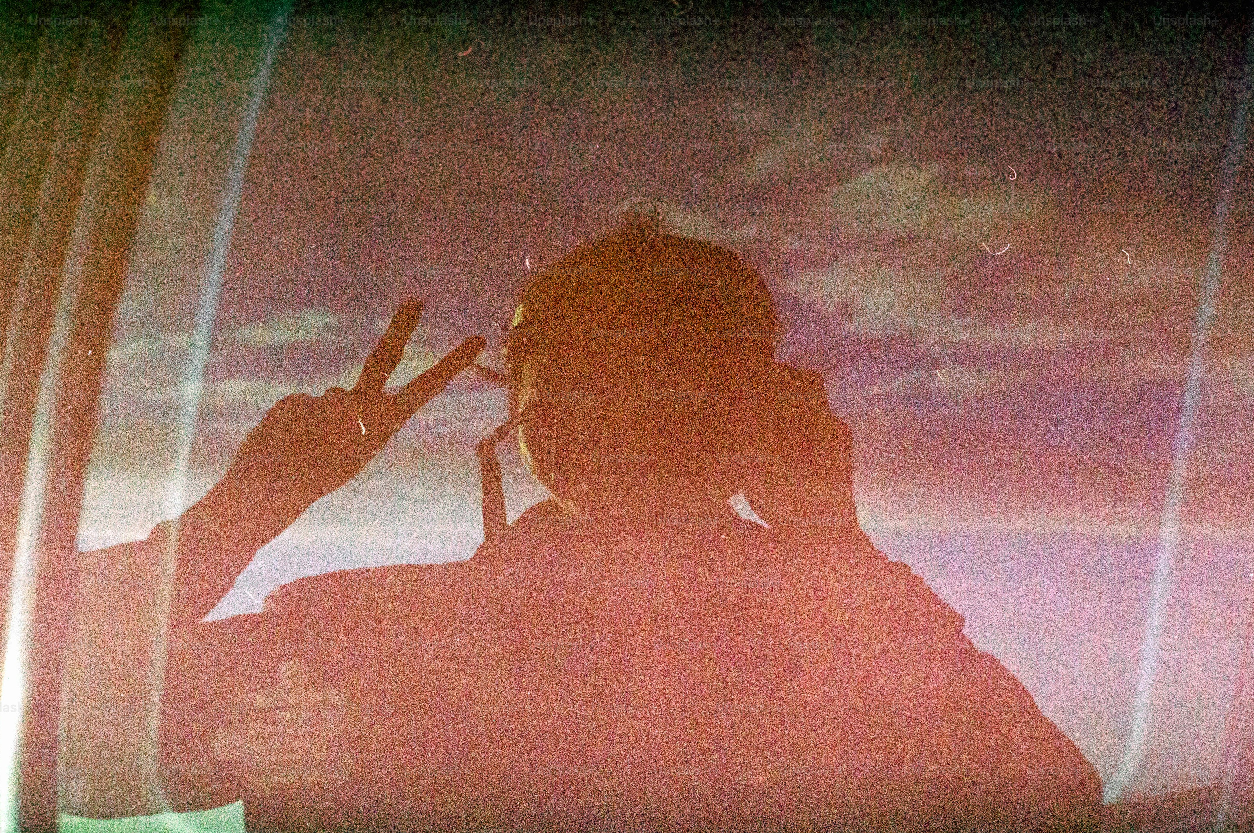 Eine Person macht in der Reflexion ein Peace-Zeichen.