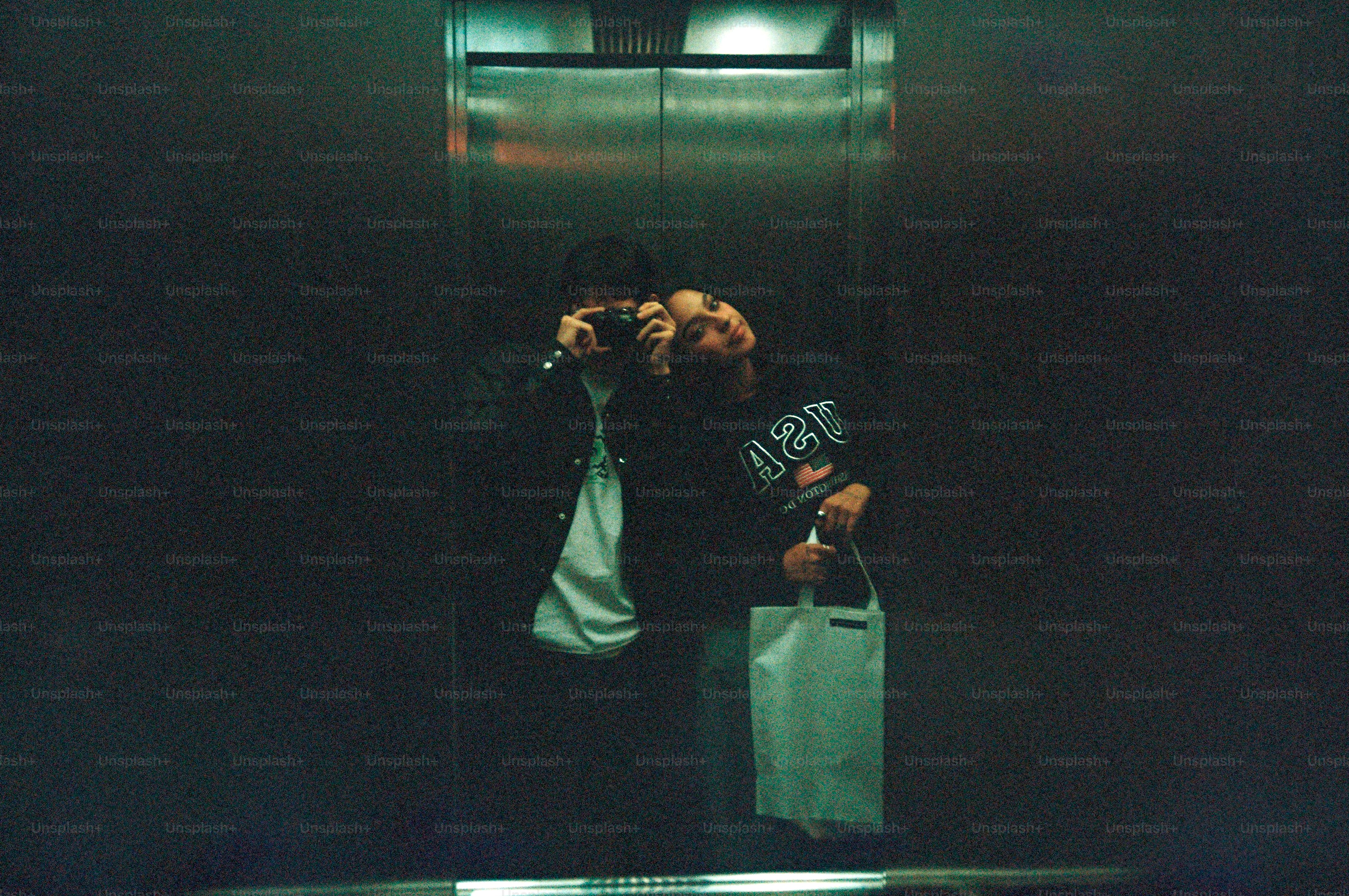 Menschen machen ein Foto in einem Aufzug.