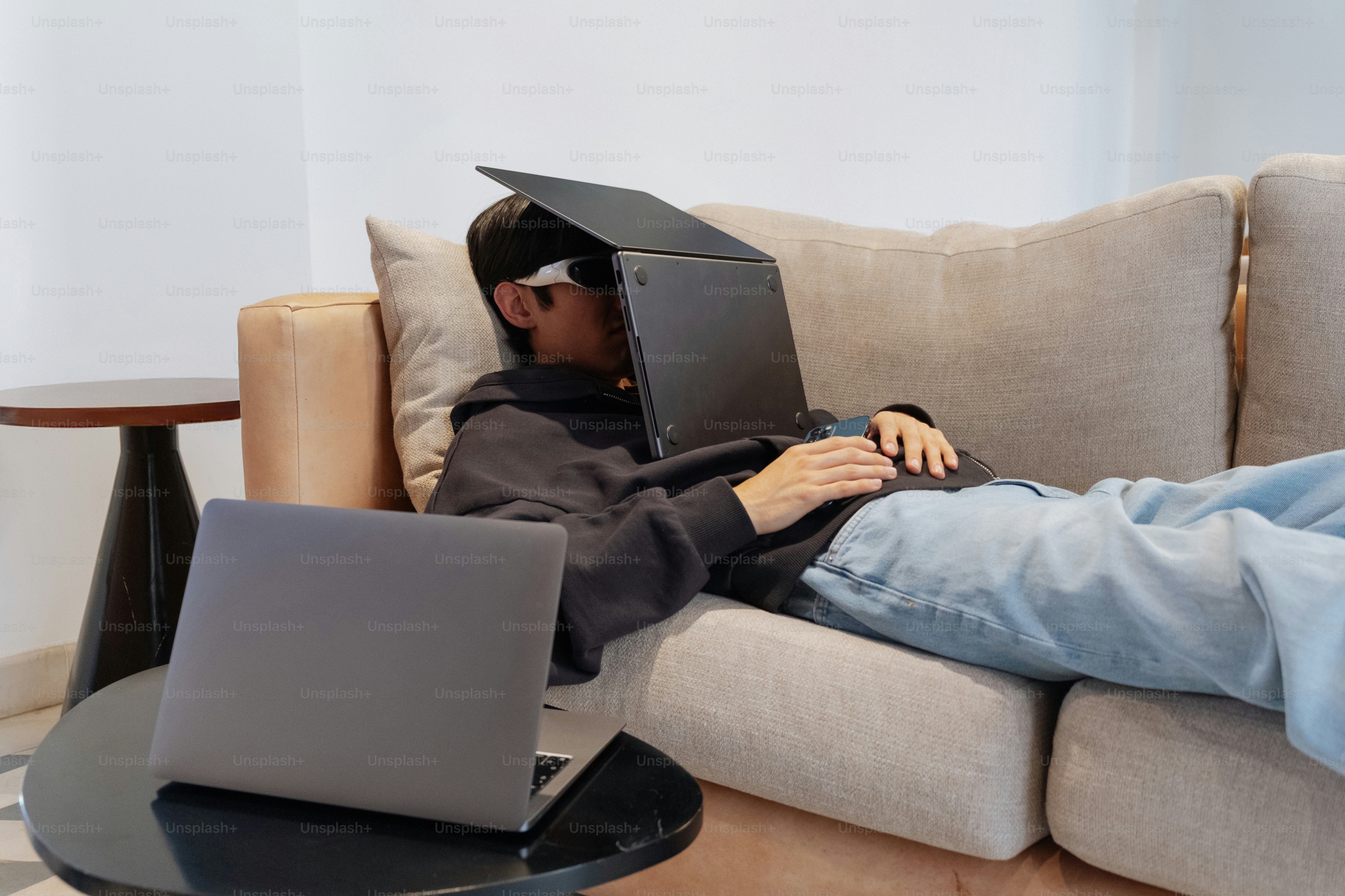 Person asleep on a couch with a laptop.