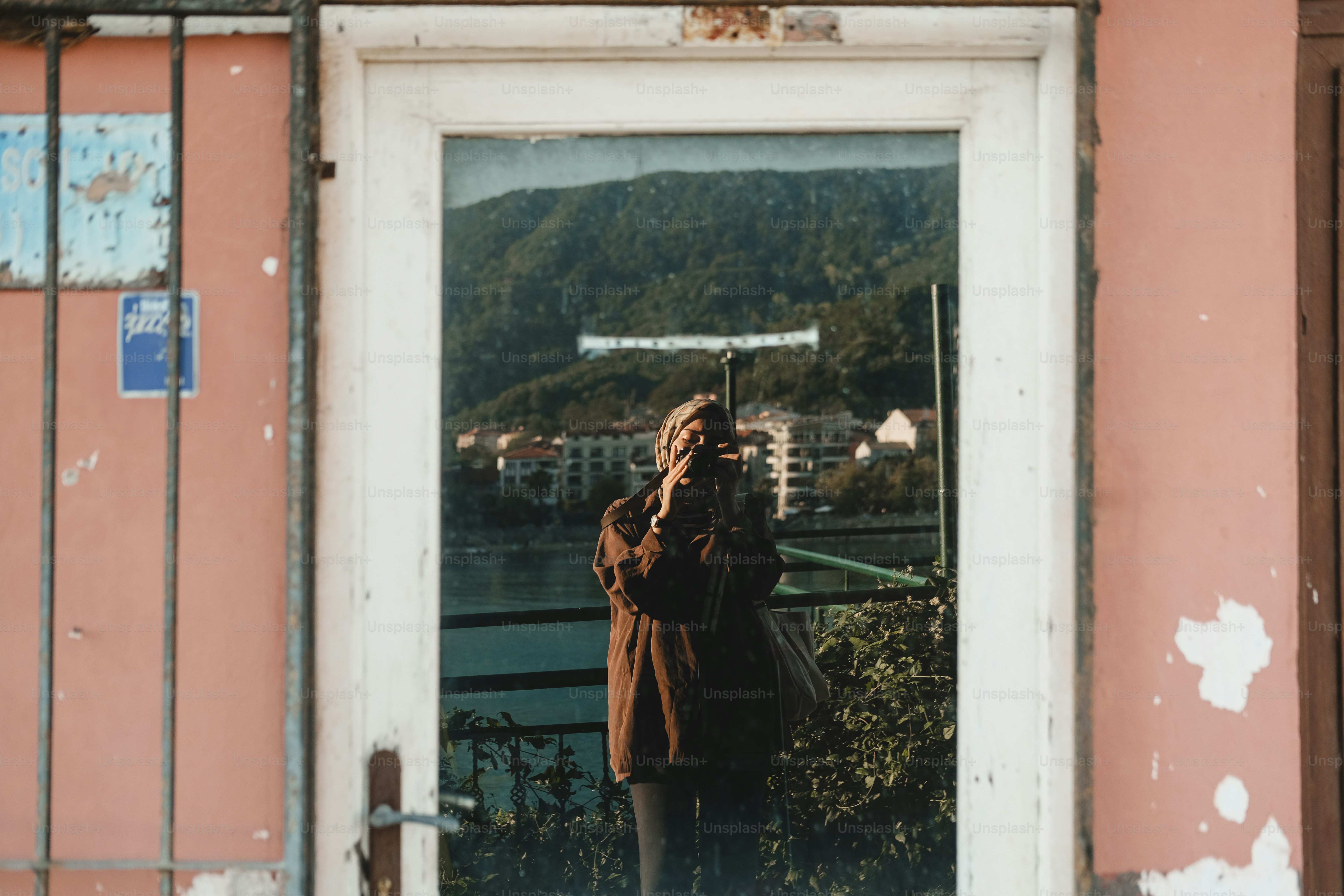 Persona che scatta una foto che si riflette in una finestra.