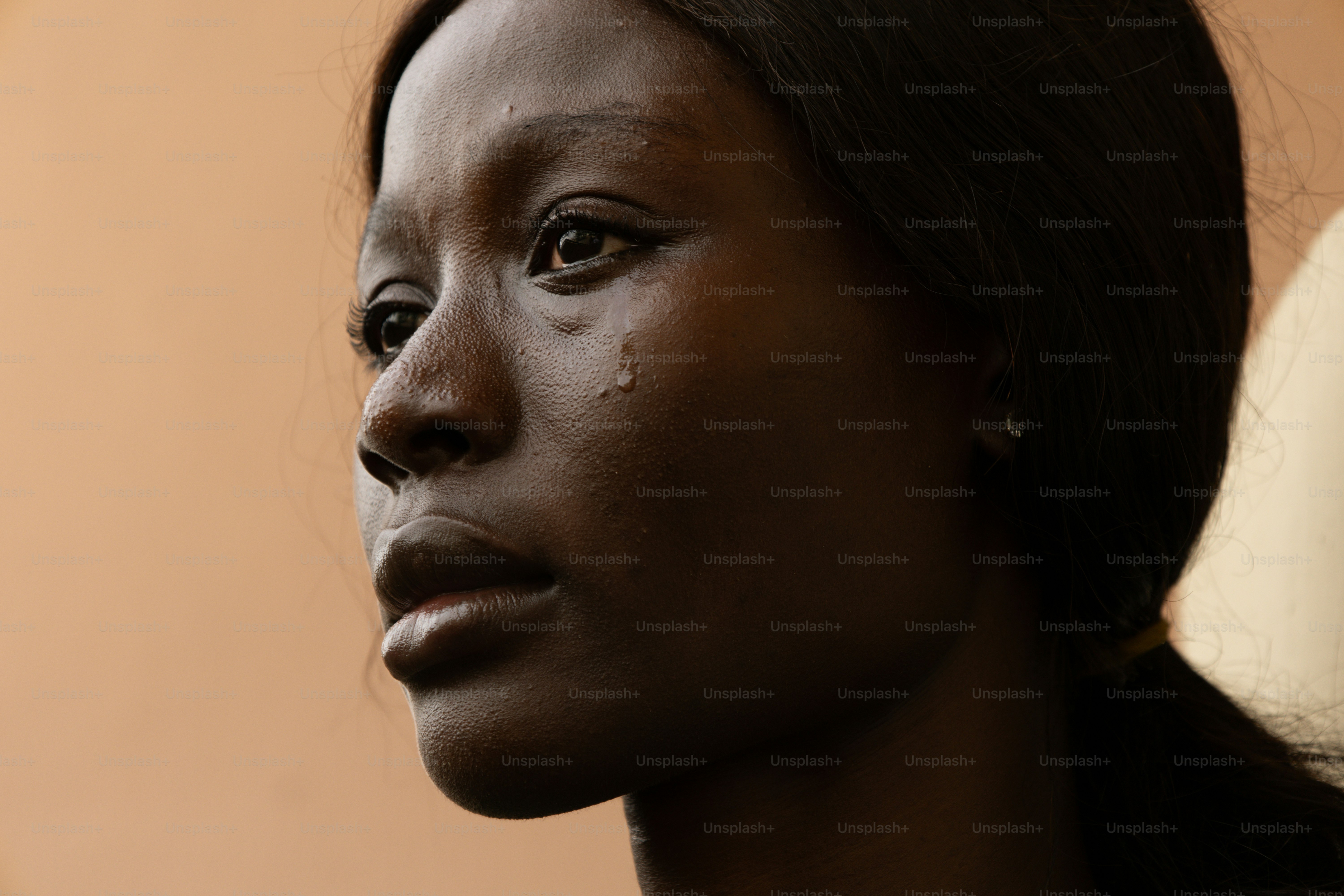 A sad woman has tears rolling down her face