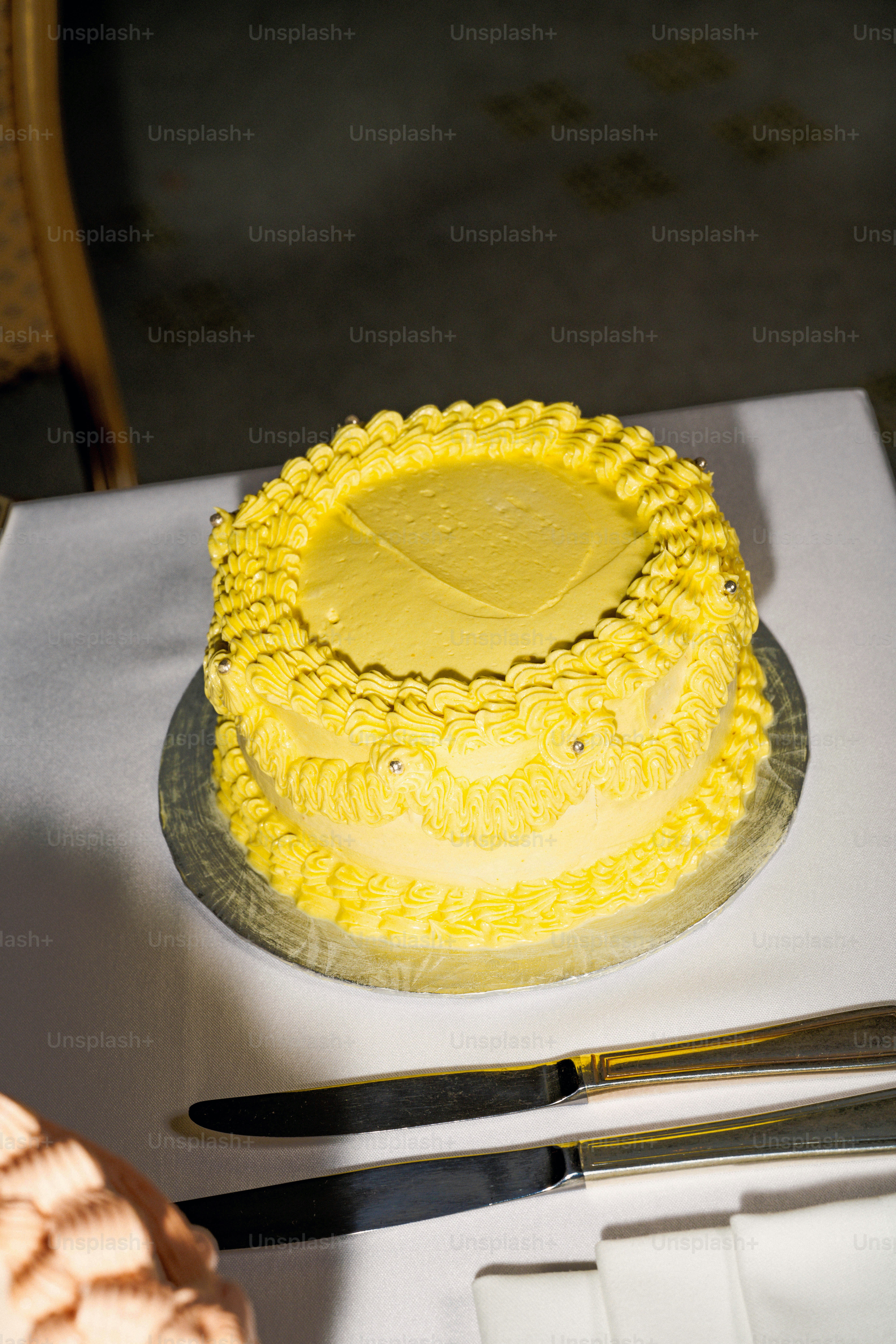 A delicious, yellow cake is ready to be cut.