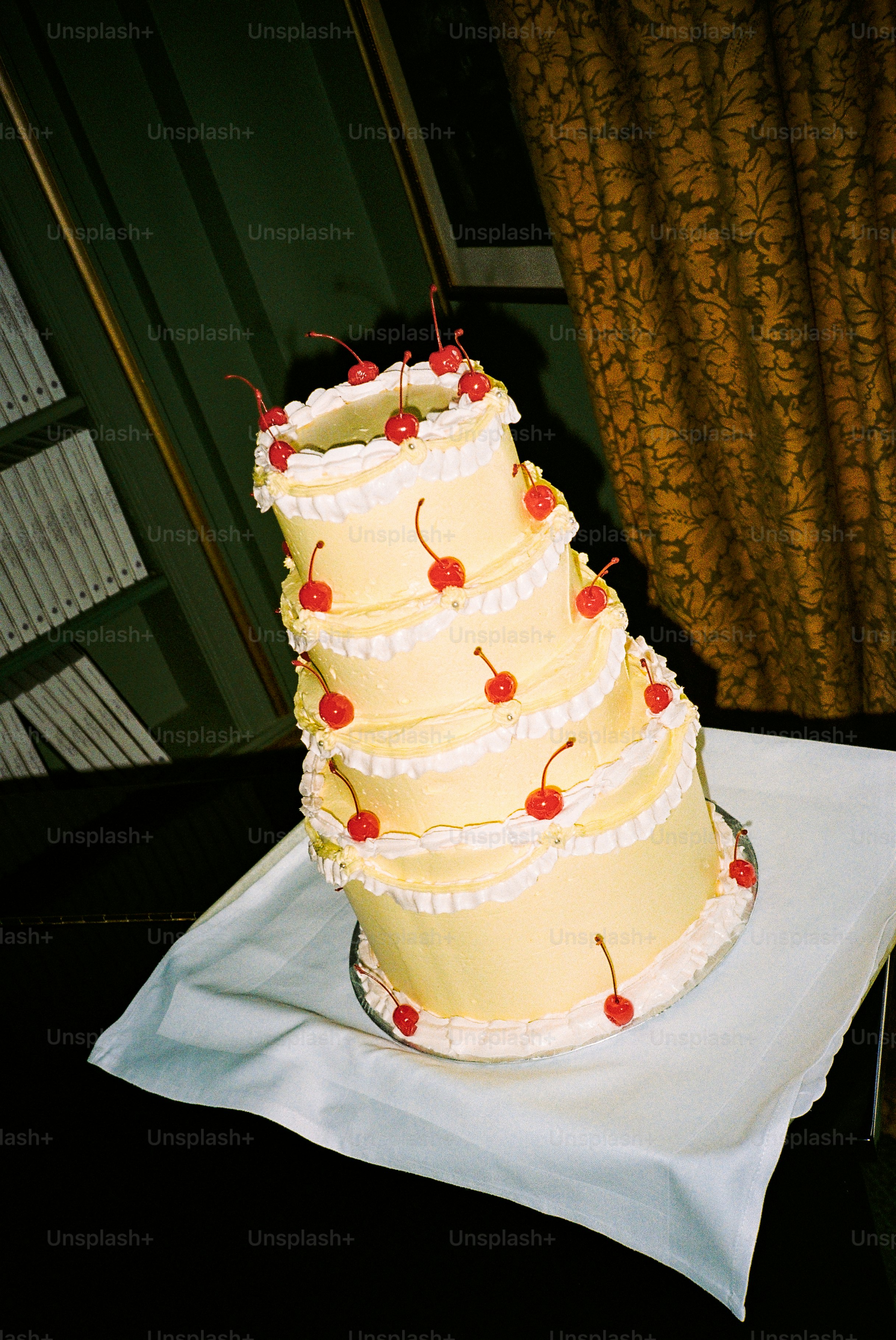 A multi-layered cake is decorated with cherries.