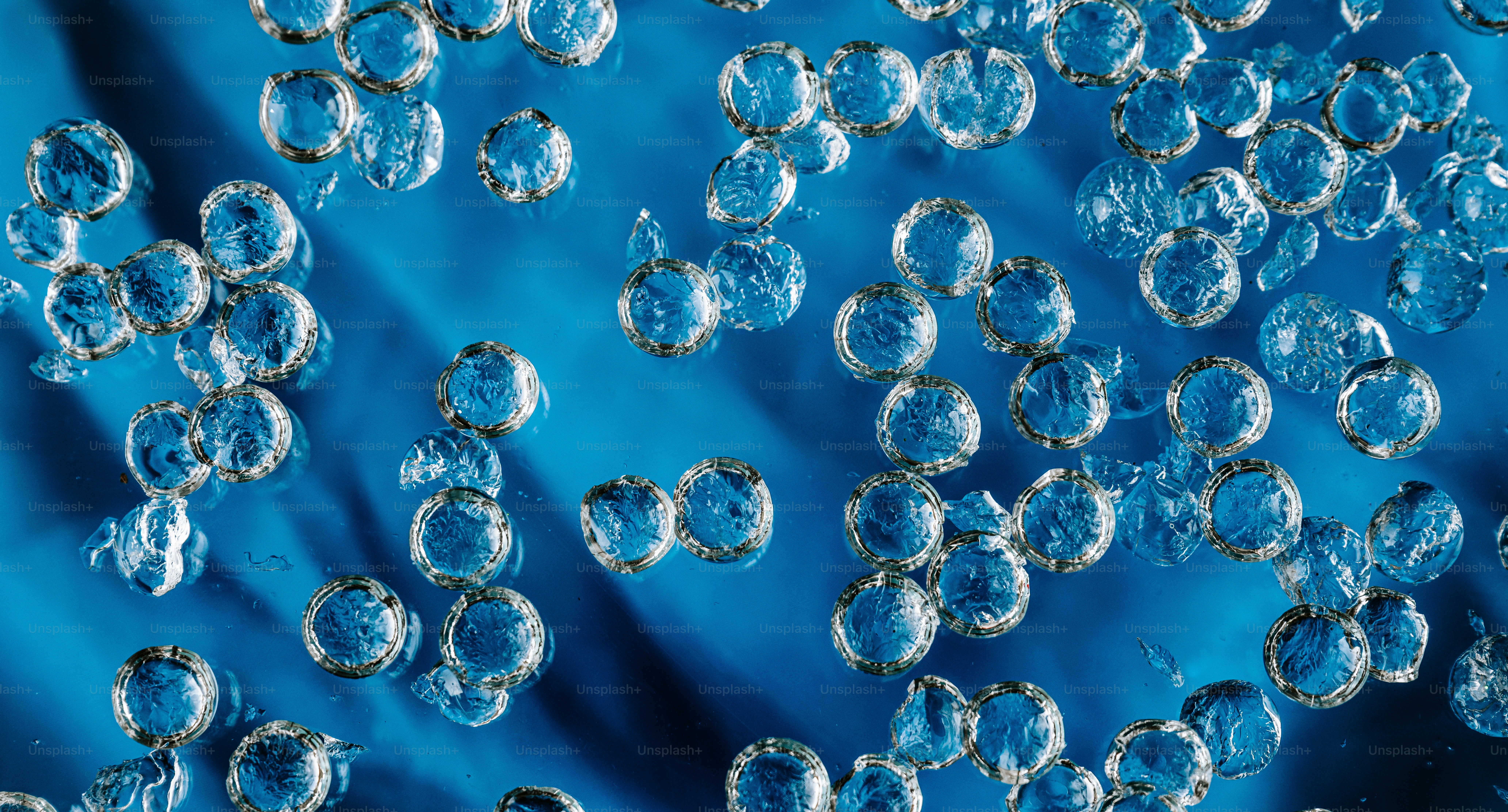 Bubbles float on a shimmering blue surface.
