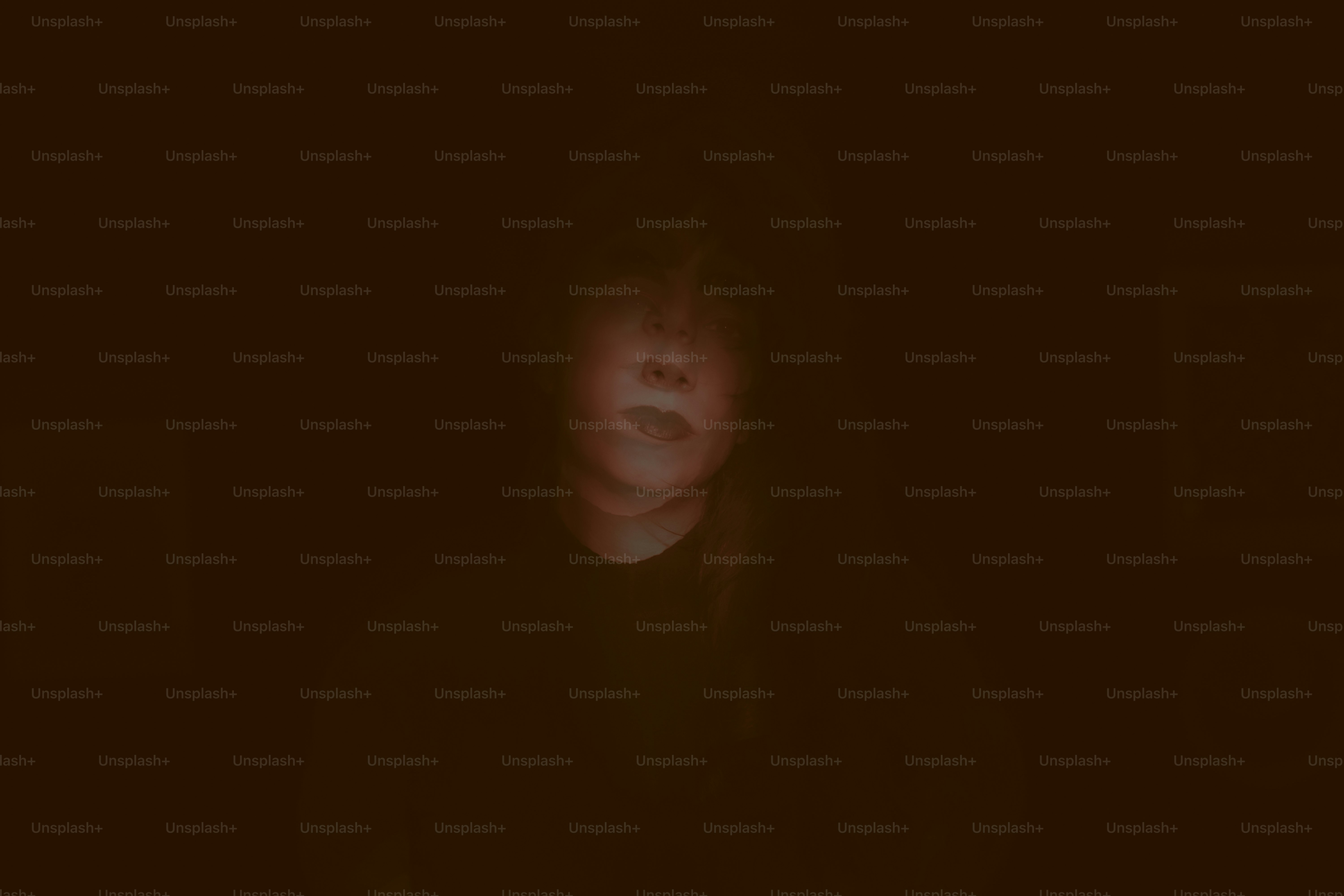 Ein schwaches Gesicht taucht aus der Dunkelheit auf.