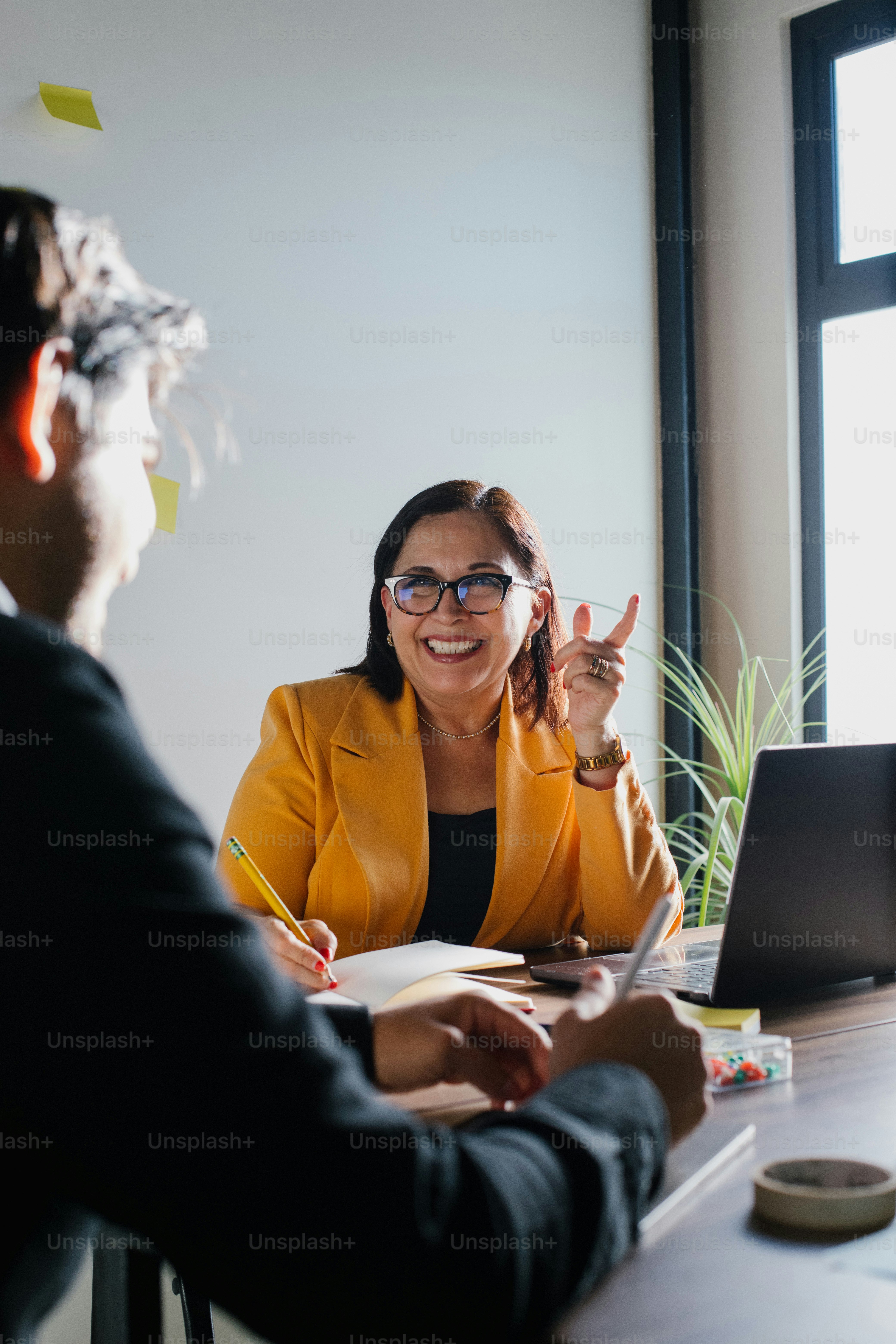Woman in a meeting makes a cheerful gesture.