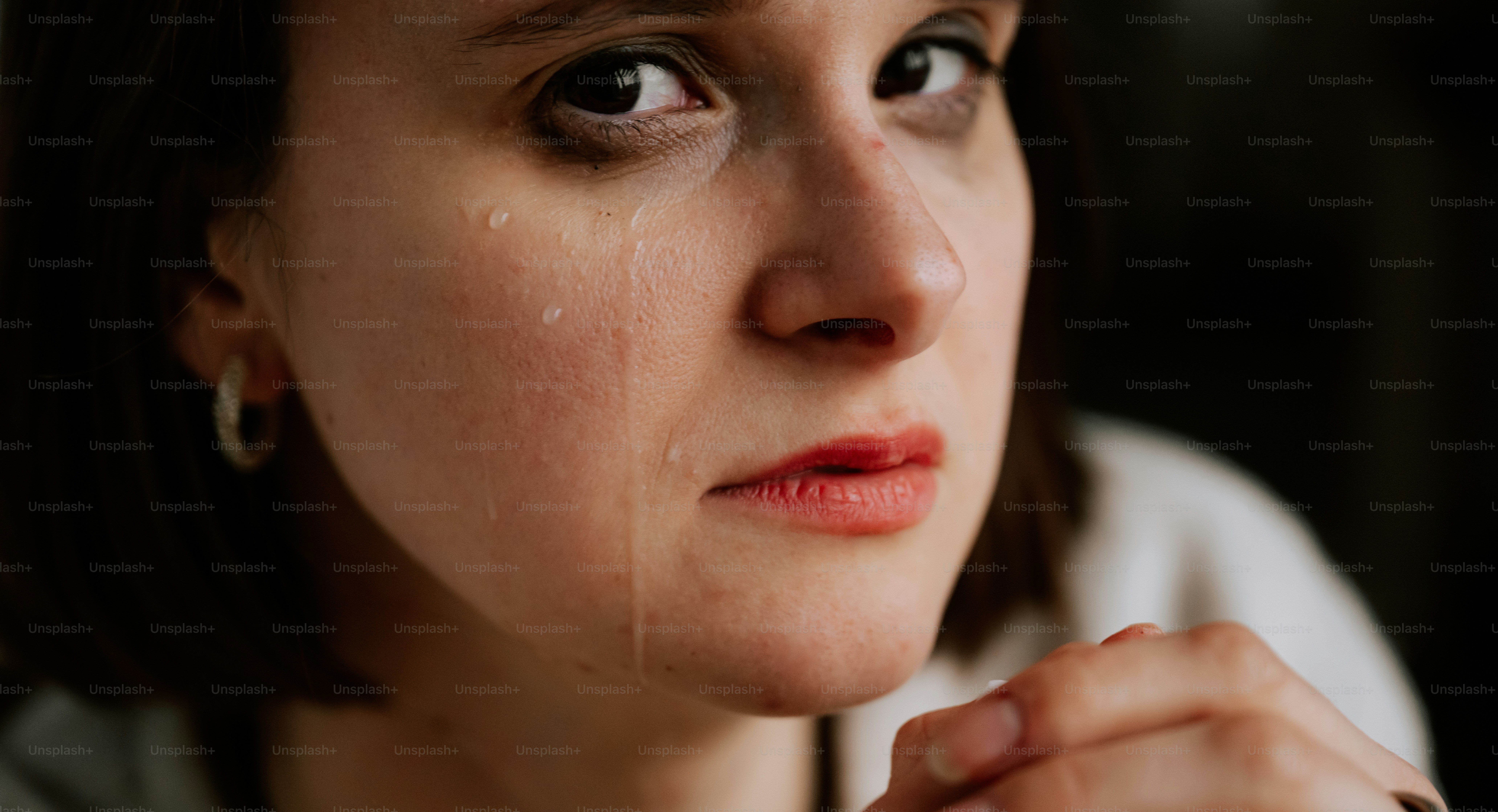 A woman is crying, tears running down her face.
