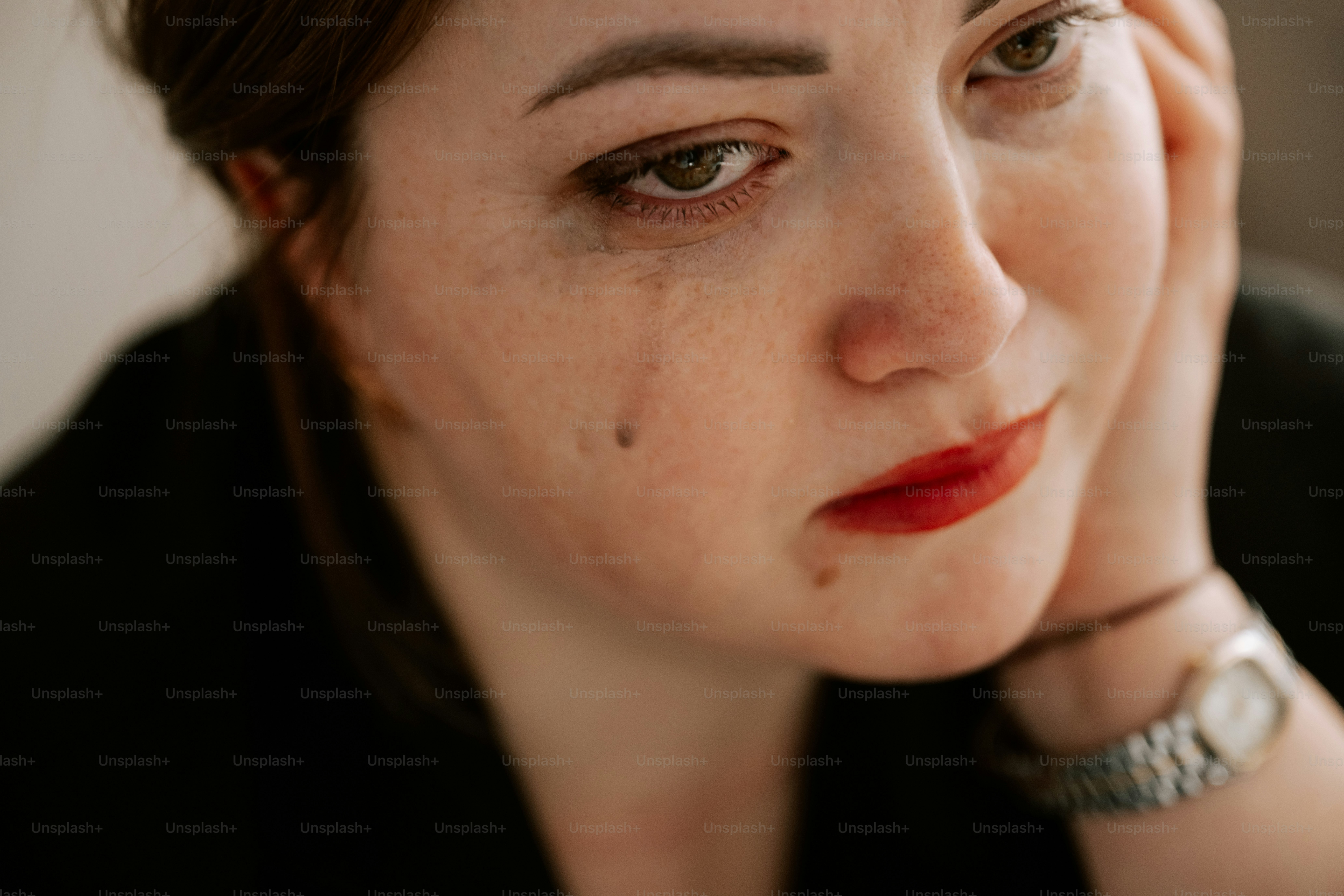 A woman sheds a tear, looking sorrowful.