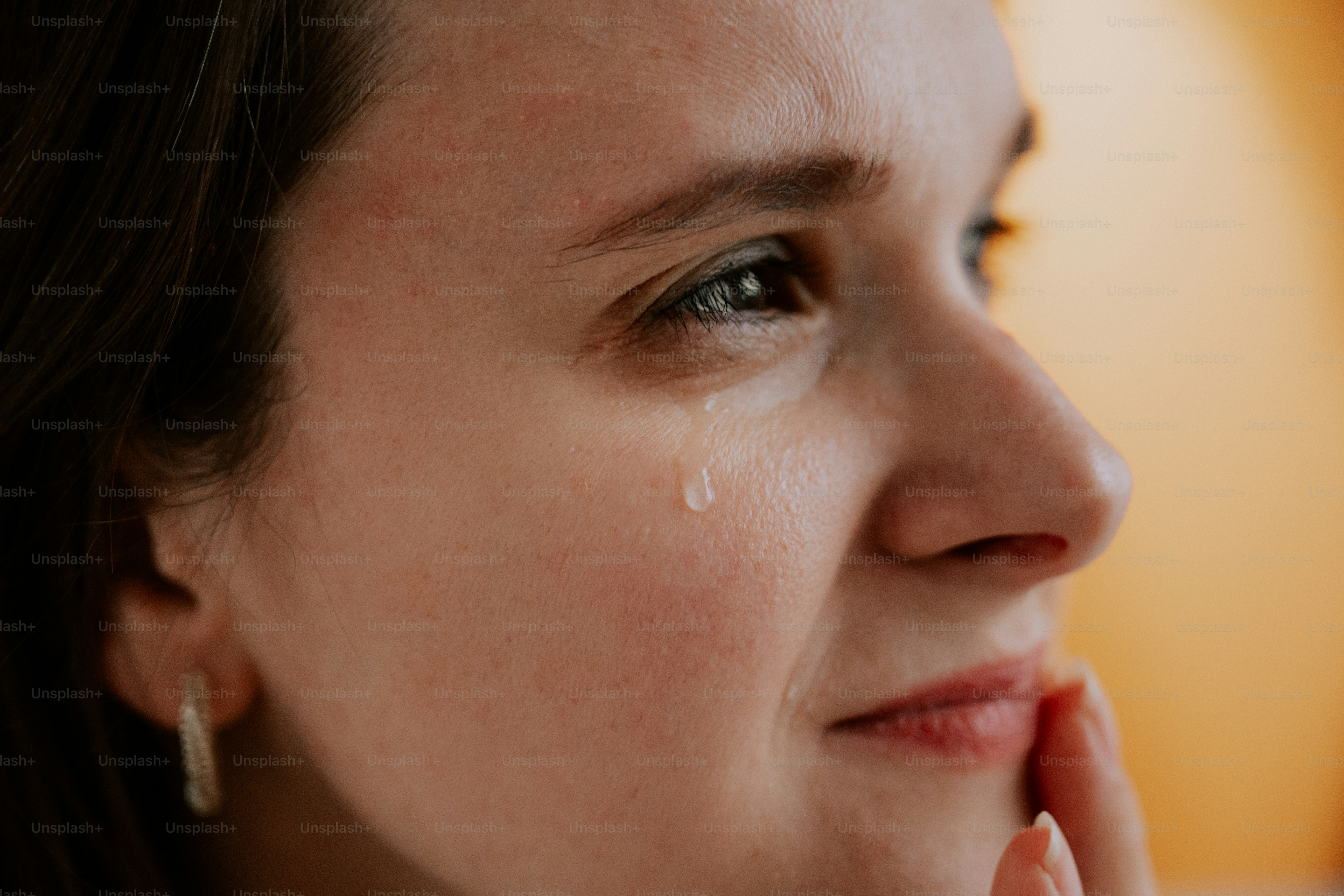A woman sheds a tear, showing emotion.