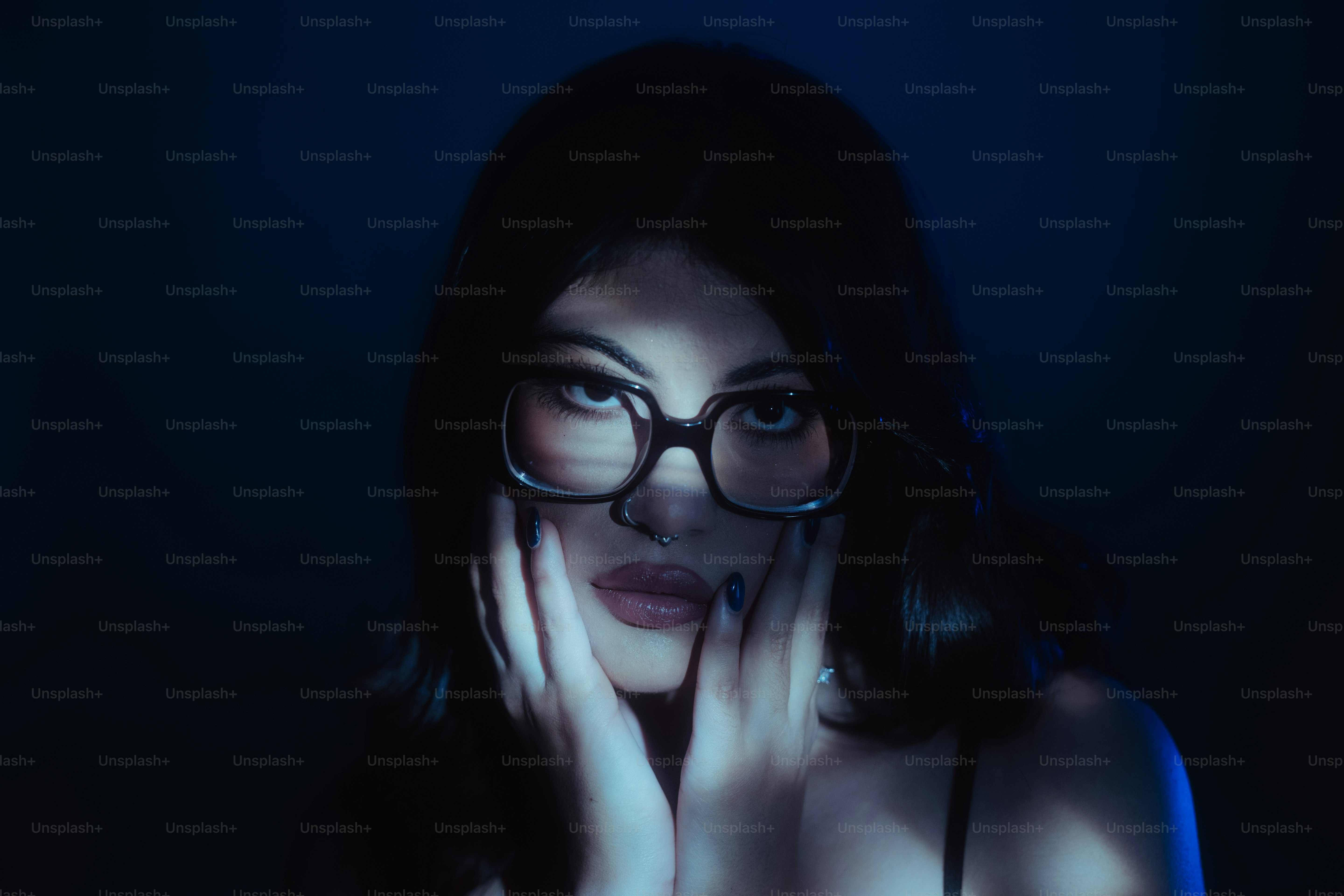 Woman wears glasses and holds her face.