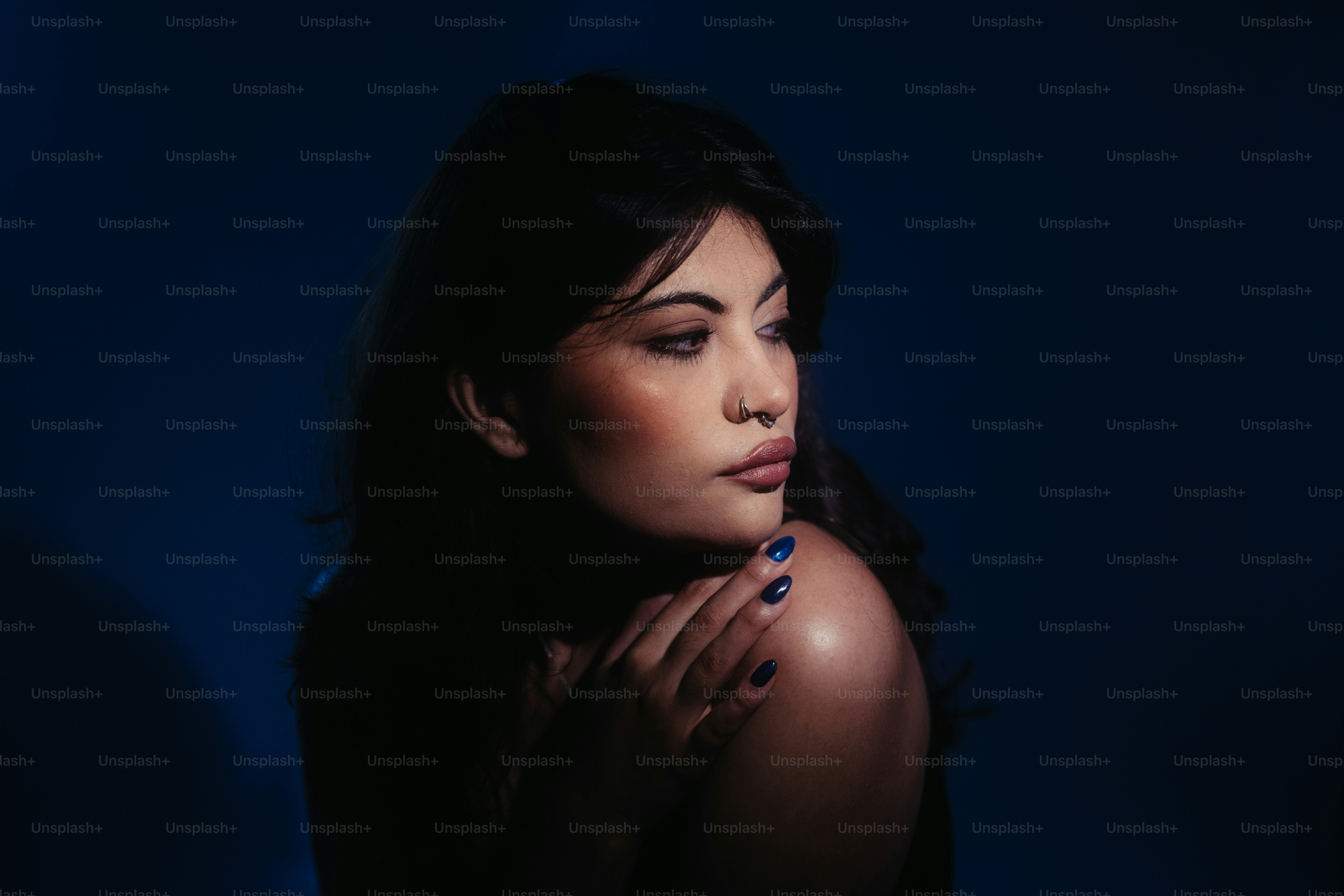 Eine Frau posiert in einem dunklen Raum.